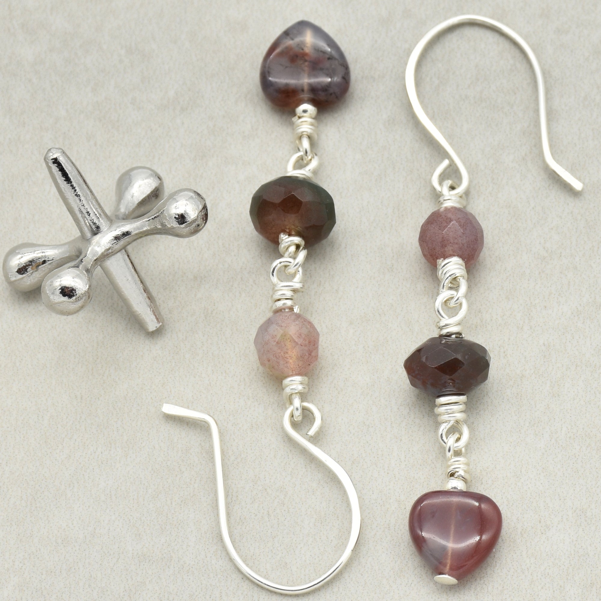 The image shows a pair of earrings. The earrings feature a combination of beads and stones, connected by wire loops, with hooks for wearing.