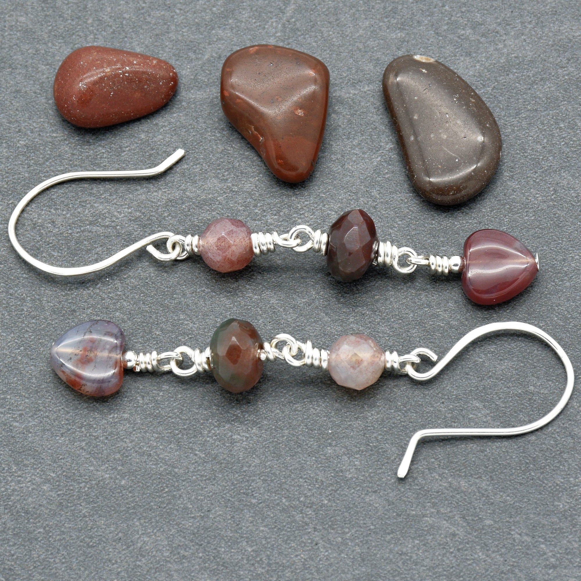 This image shows a pair of earrings. The jewelry pieces have hooks that go through pierced ears and feature a design with beads and stones strung together.