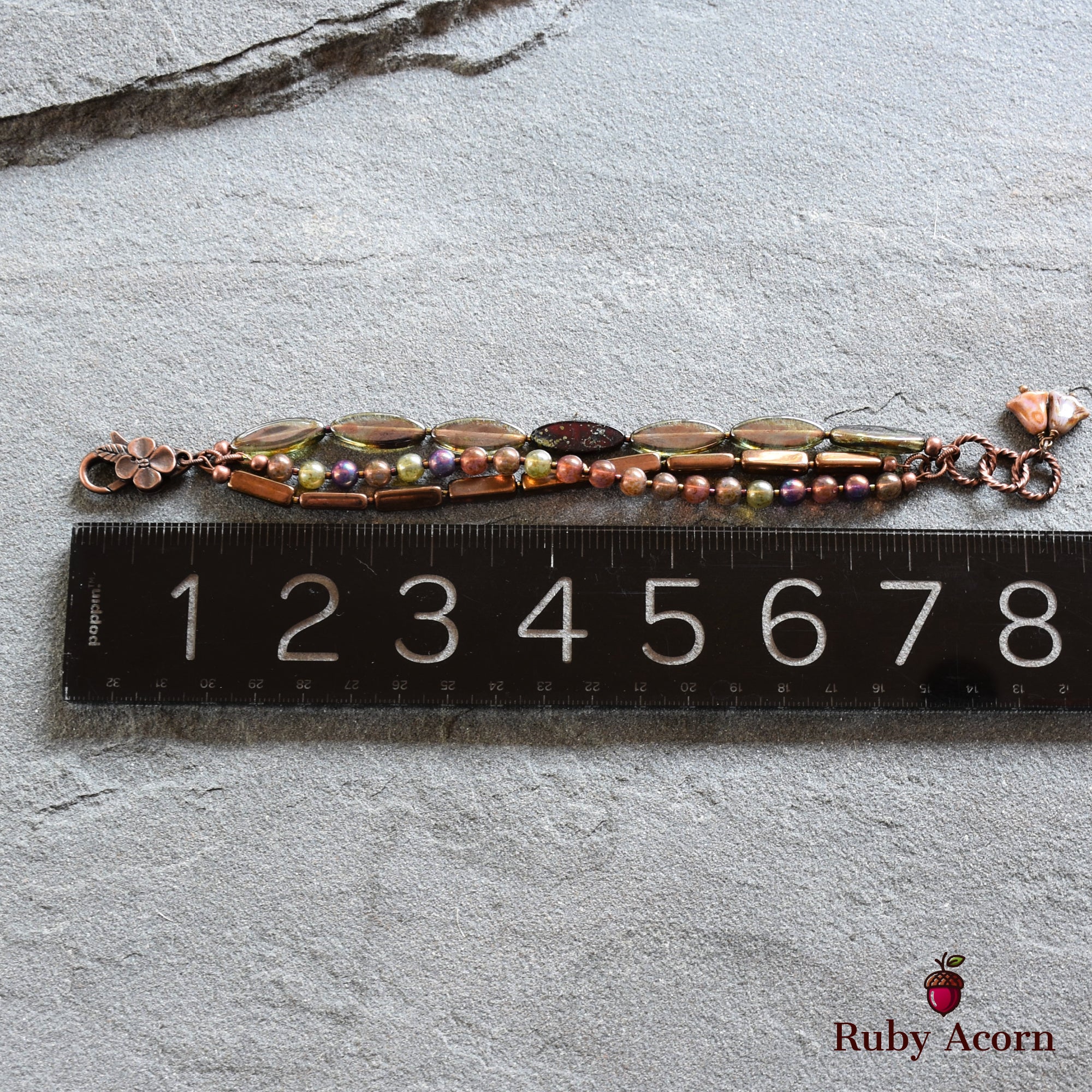 This image shows a piece of jewelry that appears to be a bracelet. The length is quite short, approximately 7 inches based on the ruler placed next to it, which aligns with typical bracelet sizes. Necklaces are generally much longer, and earrings are usually designed in pairs and are not this long. The clasp and decorative beads also suggest it's a bracelet.