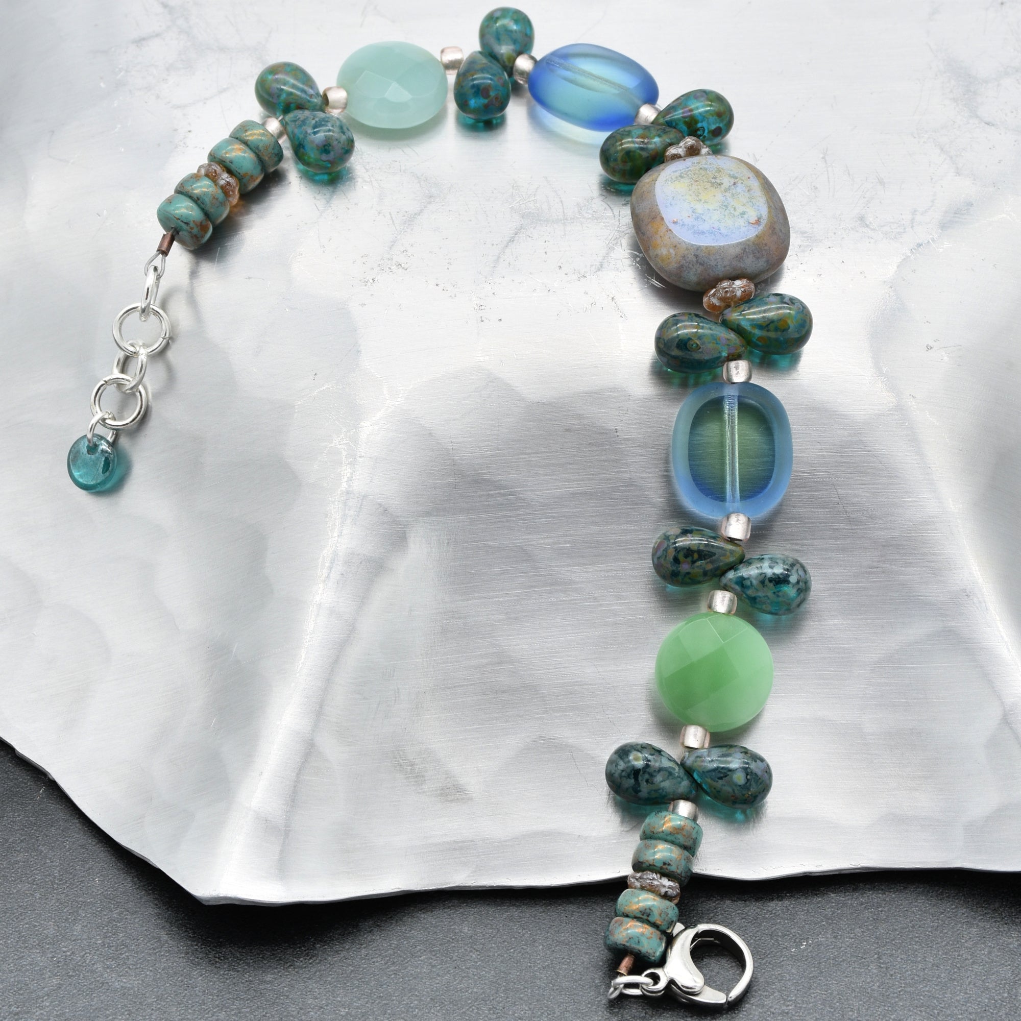 This image shows a bracelet. The jewelry piece is relatively short and has a clasp, which is typical for bracelets rather than necklaces or earrings. The design includes various bead shapes and colors, strung together with a metal clasp for fastening around the wrist.