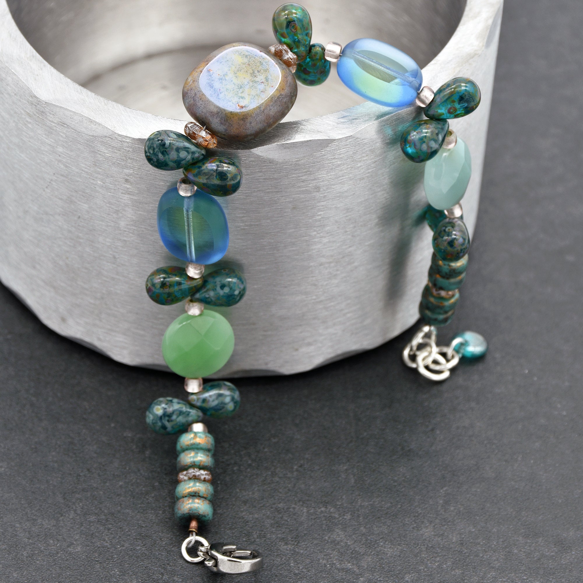 This image shows a bracelet. The size and arrangement of the beads, as well as the clasp at the end, are typical characteristics of a bracelet. It is unlikely to be a necklace because it is relatively short, and it cannot be an earring due to its shape and length.