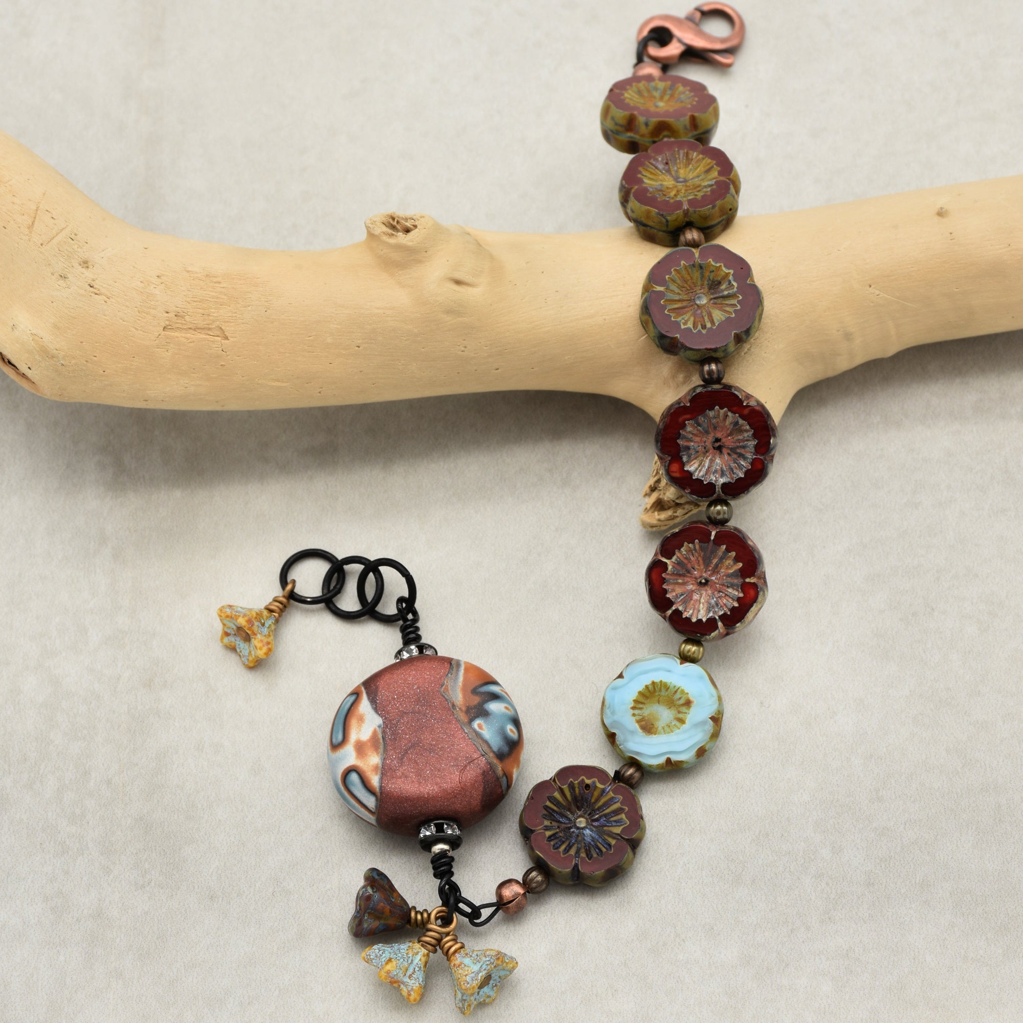 The jewelry in the image is a bracelet. It has a clasp and is composed of flower-shaped beads and other decorative beads, suggesting it is designed to fit around the wrist.