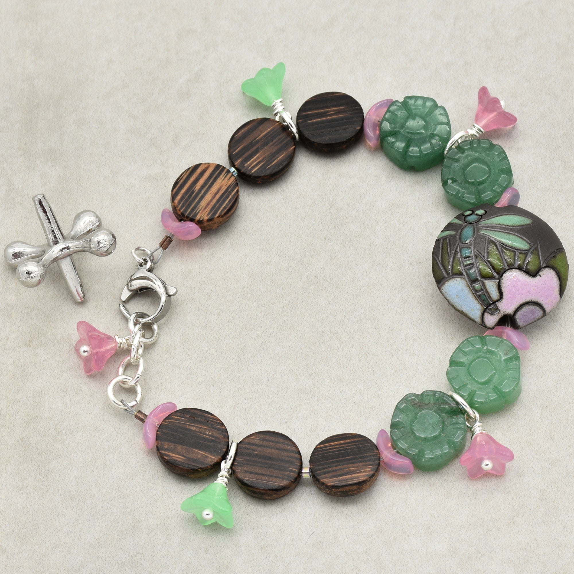 This image shows a bracelet. The circular arrangement and the size of the clasp, along with the decorative beads and charms, indicate that it is designed to be worn around the wrist.