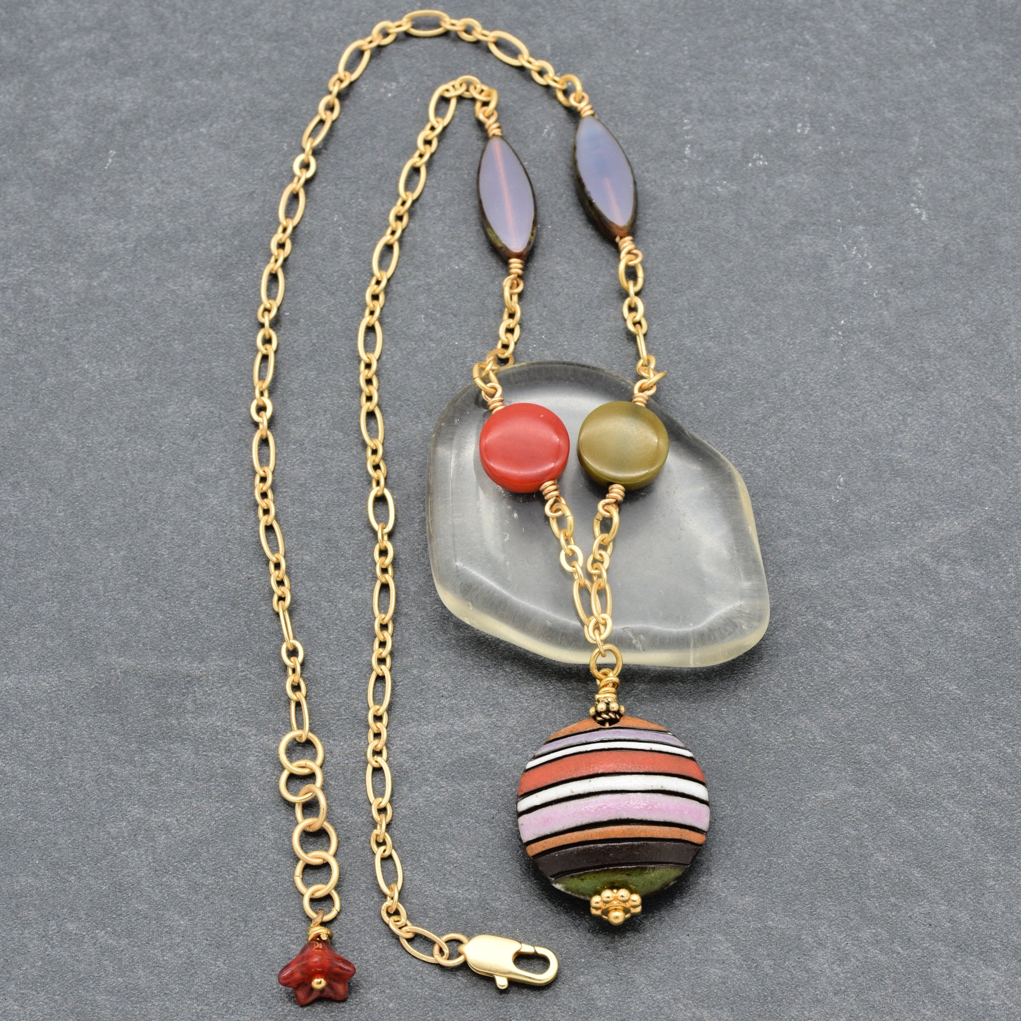 This image shows a necklace. The chain is long and has a clasp, and there is a decorative pendant with various colored beads, which is typical for a necklace rather than an earring or bracelet.