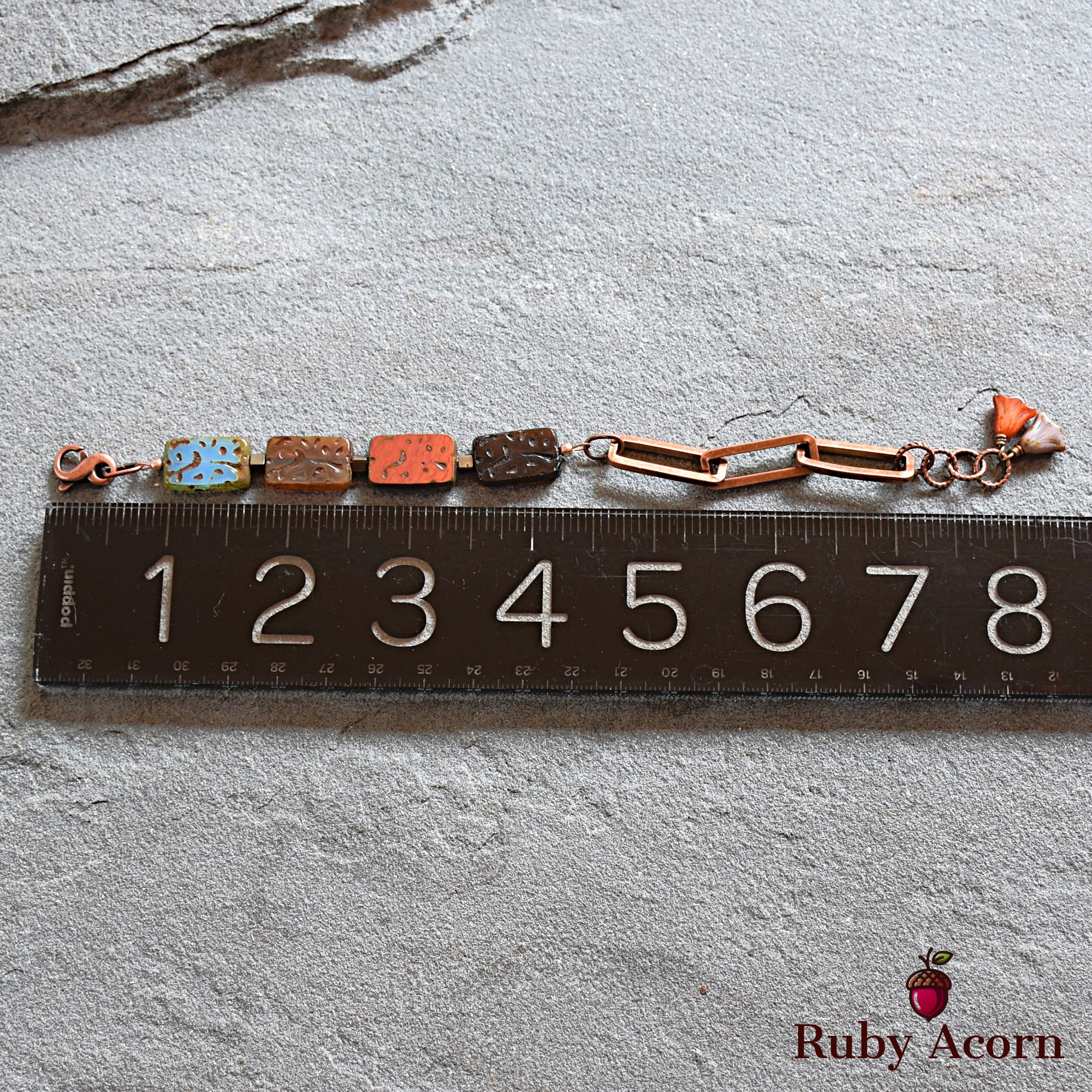 This image shows a bracelet. The length and design, including the linked chain and clasp, indicate that it is intended to be worn around the wrist. The ruler beneath the bracelet suggests it is about 7 to 8 inches long, which is a typical size for a bracelet.