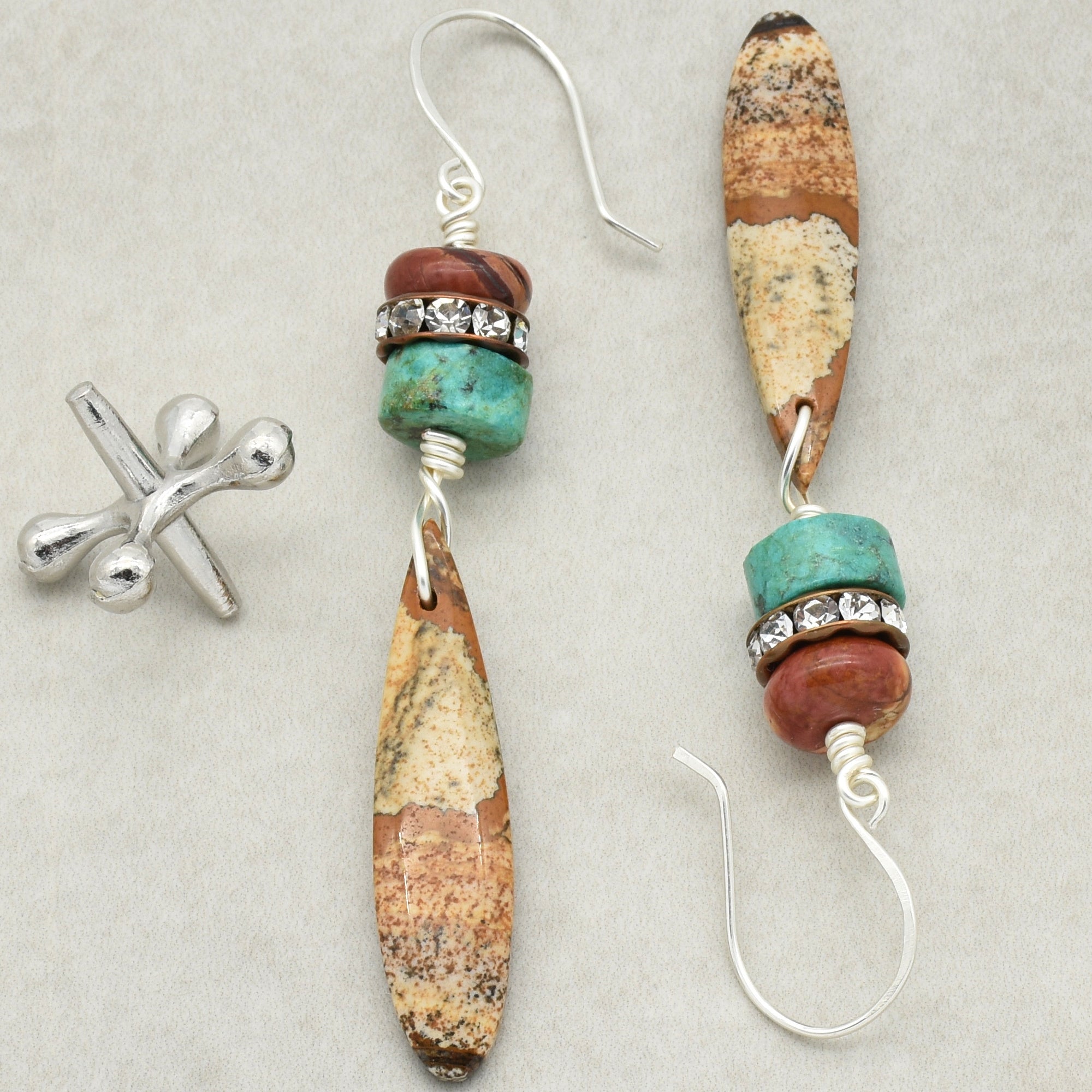 This image shows a pair of earrings. The hooks at the top are designed to go through pierced ears, which is characteristic of earrings.