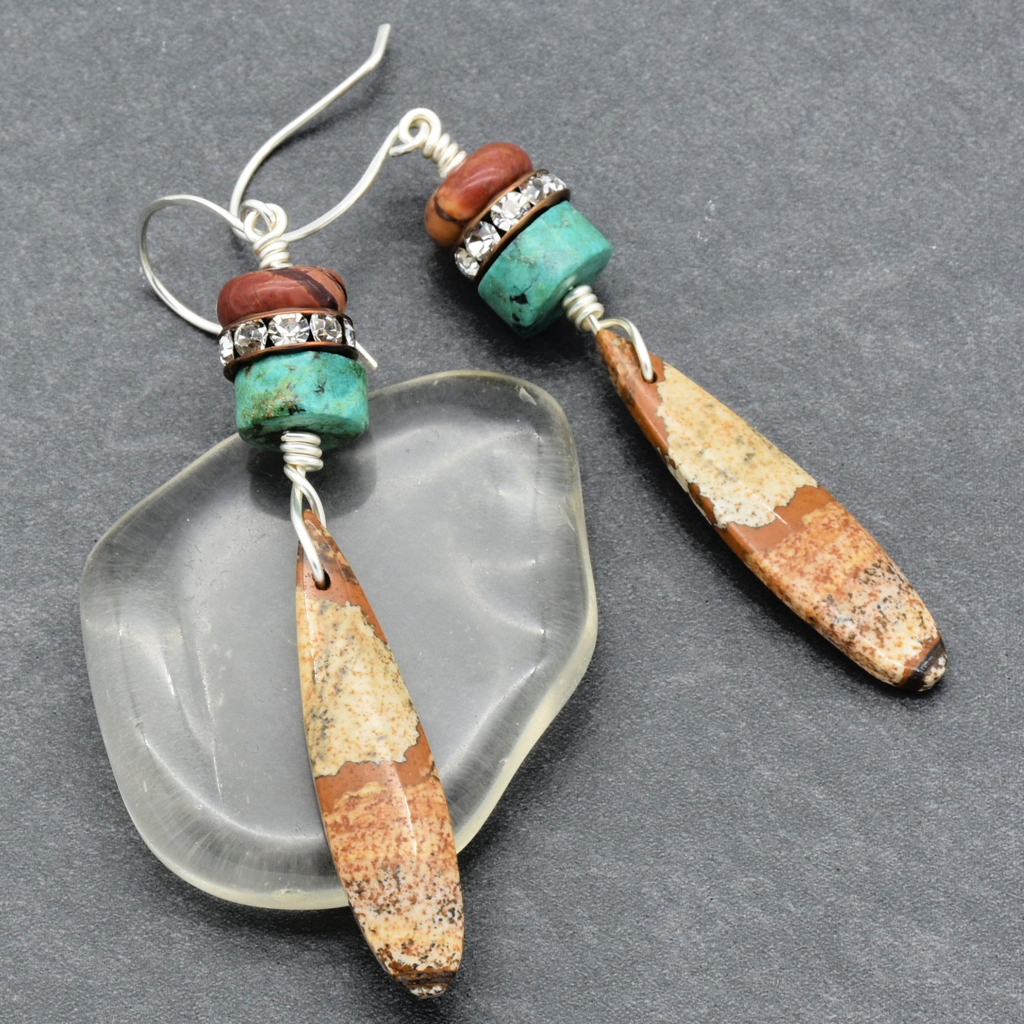 These are earrings. The jewelry pieces have hooks designed to go through pierced ears, which is characteristic of earrings.