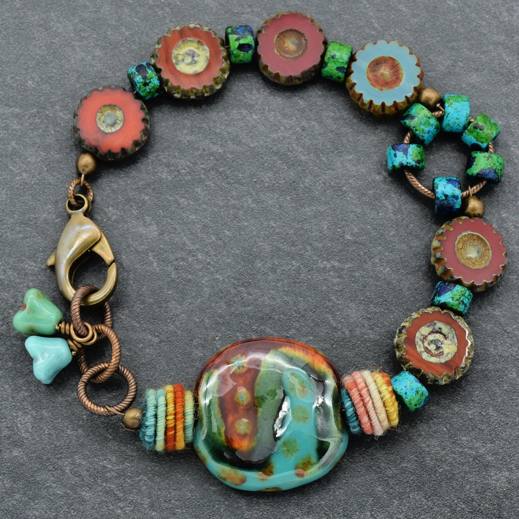 This image shows a bracelet. It features colorful beads including round, turquoise, and orange elements, with a clasp designed to fasten around a wrist. The size and shape are consistent with a bracelet rather than a necklace or an earring.
