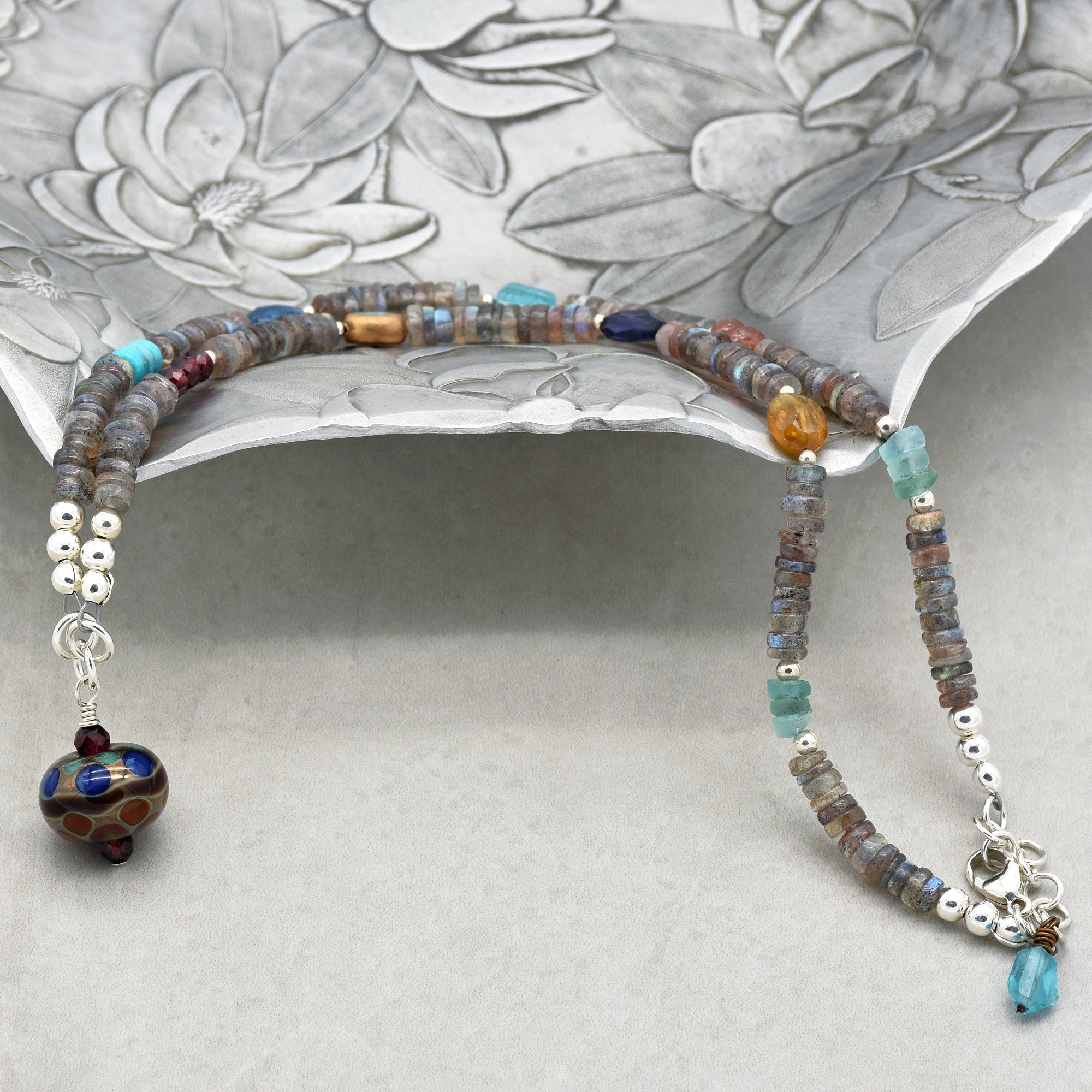 This image shows a necklace. The length and style, with beads strung together and a decorative pendant at the end, indicate that it is designed to be worn around the neck.