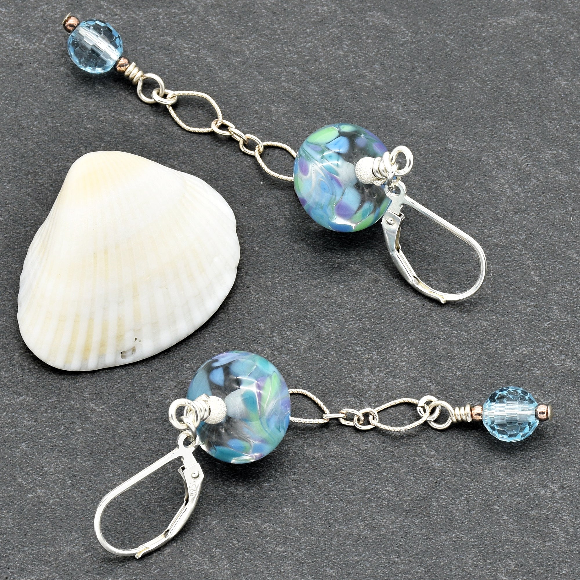 The image shows a pair of earrings. You can identify them by the earring hooks attached to the decorative beads and chains.