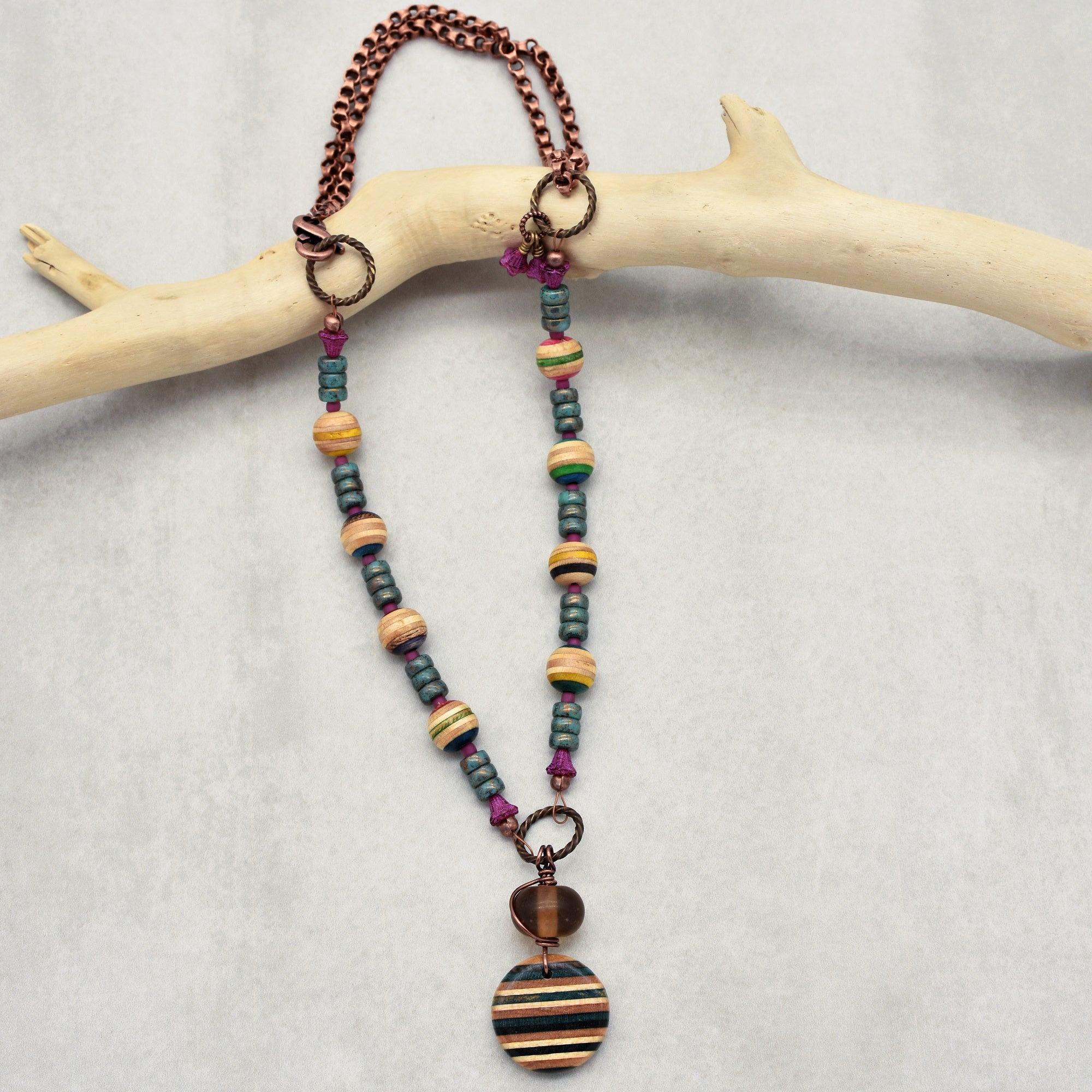 This image shows a necklace. The jewelry piece has a chain with beads and a circular pendant hanging in the center, indicating it is designed to be worn around the neck.