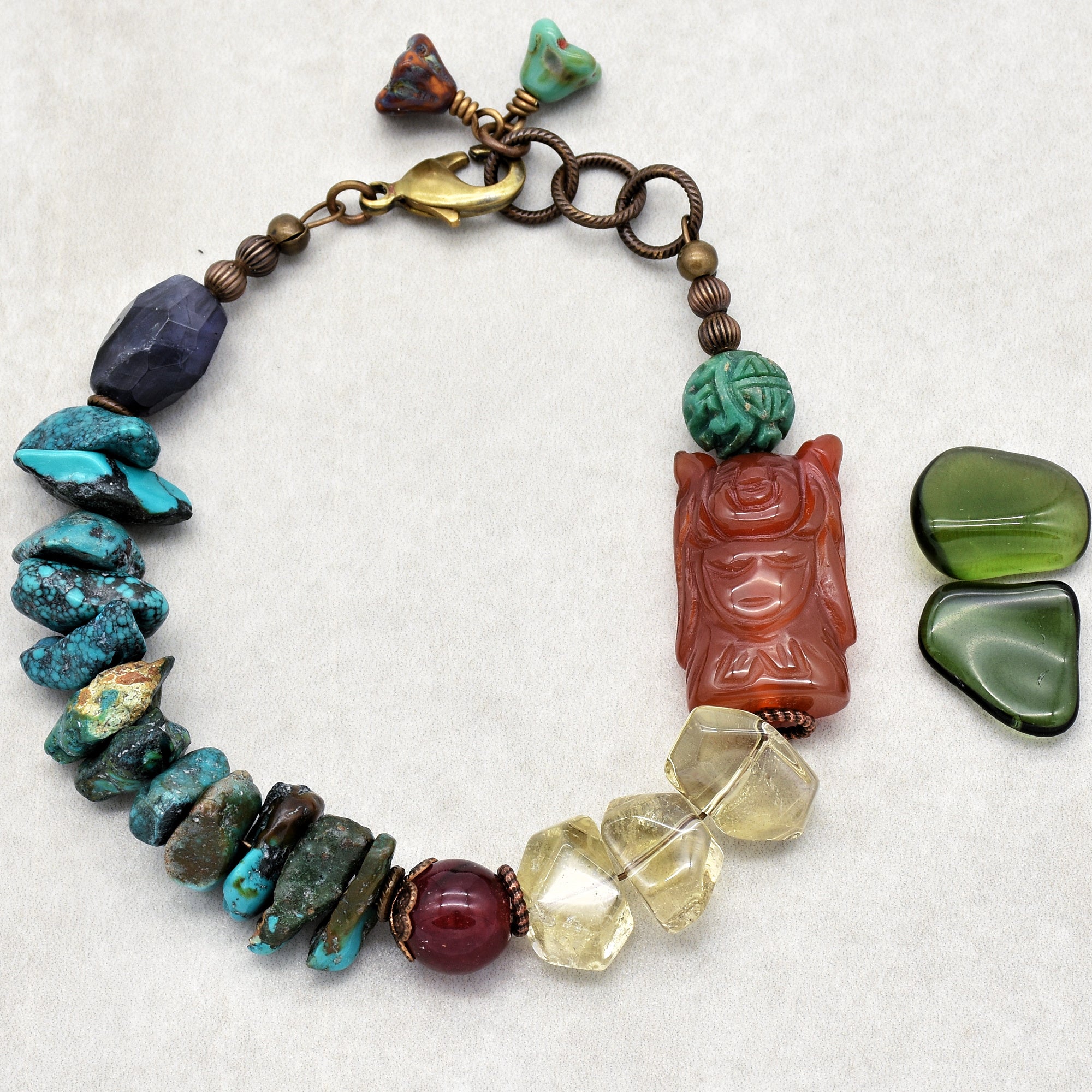 This image shows a bracelet. It is a circular piece of jewelry with various beads and stones strung together, and it has a clasp for fastening, which are characteristic features of a bracelet.