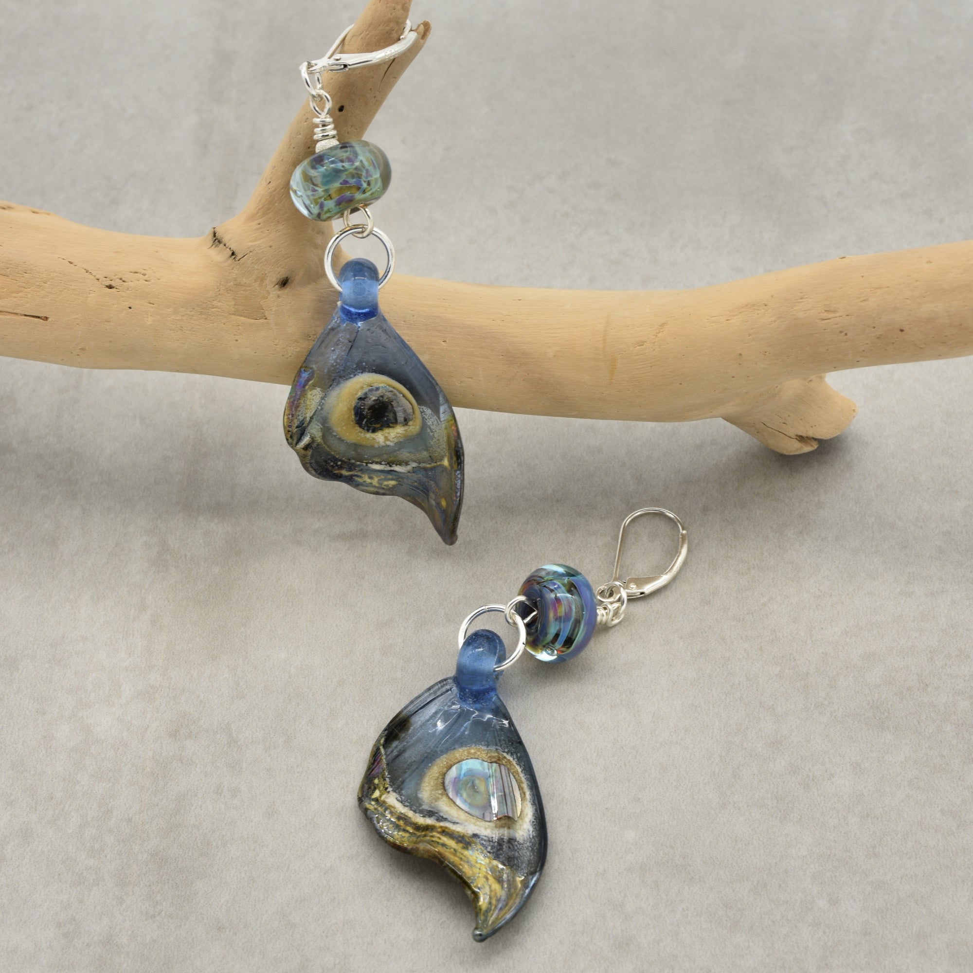This image shows a pair of earrings. The jewelry items have hooks designed for pierced ears, and the dangle style with beads and glass-like decorative elements confirms they are earrings rather than a necklace or bracelet.