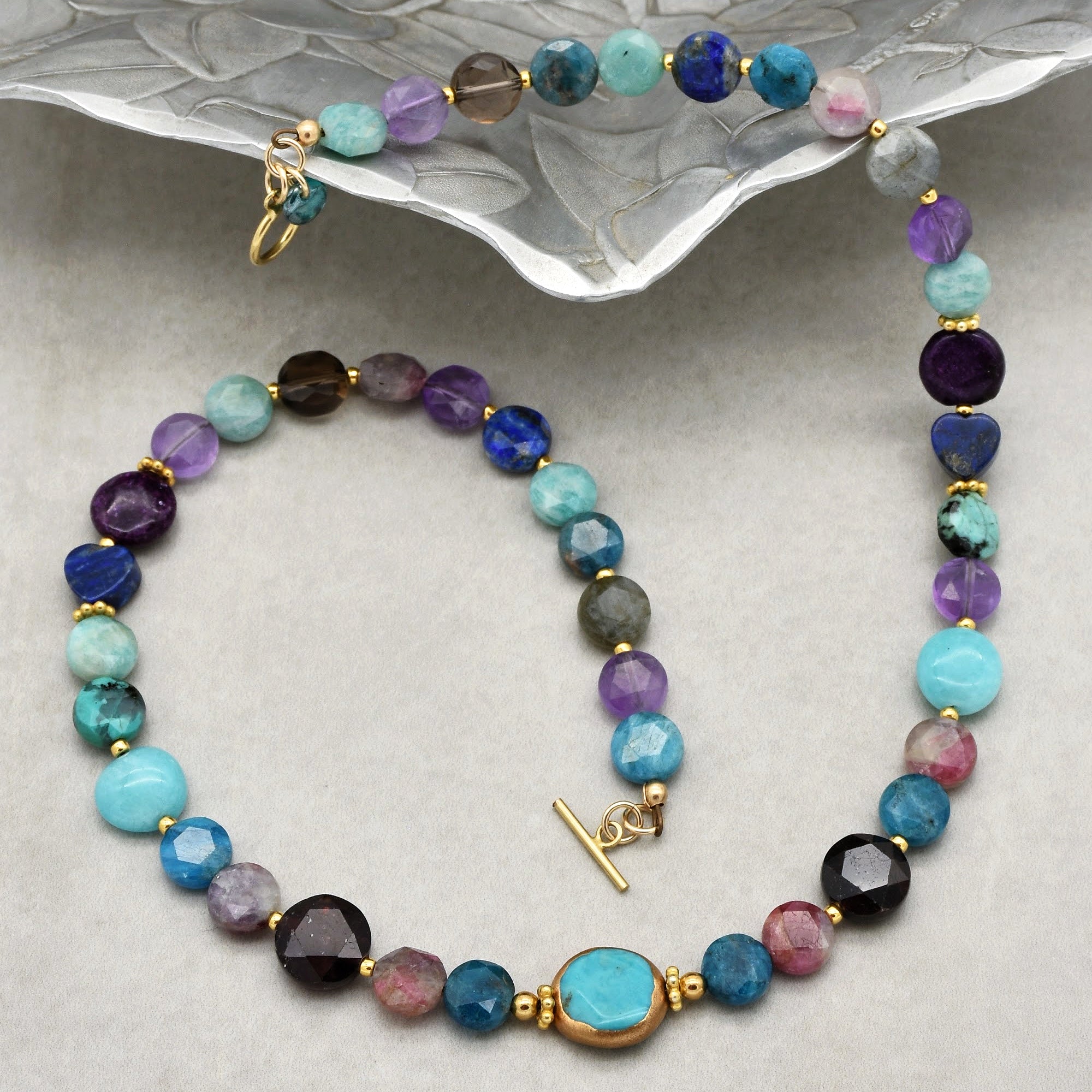 This image shows a necklace. The jewelry piece is composed of various colorful beads strung together, with a clasp that is typical for necklaces.