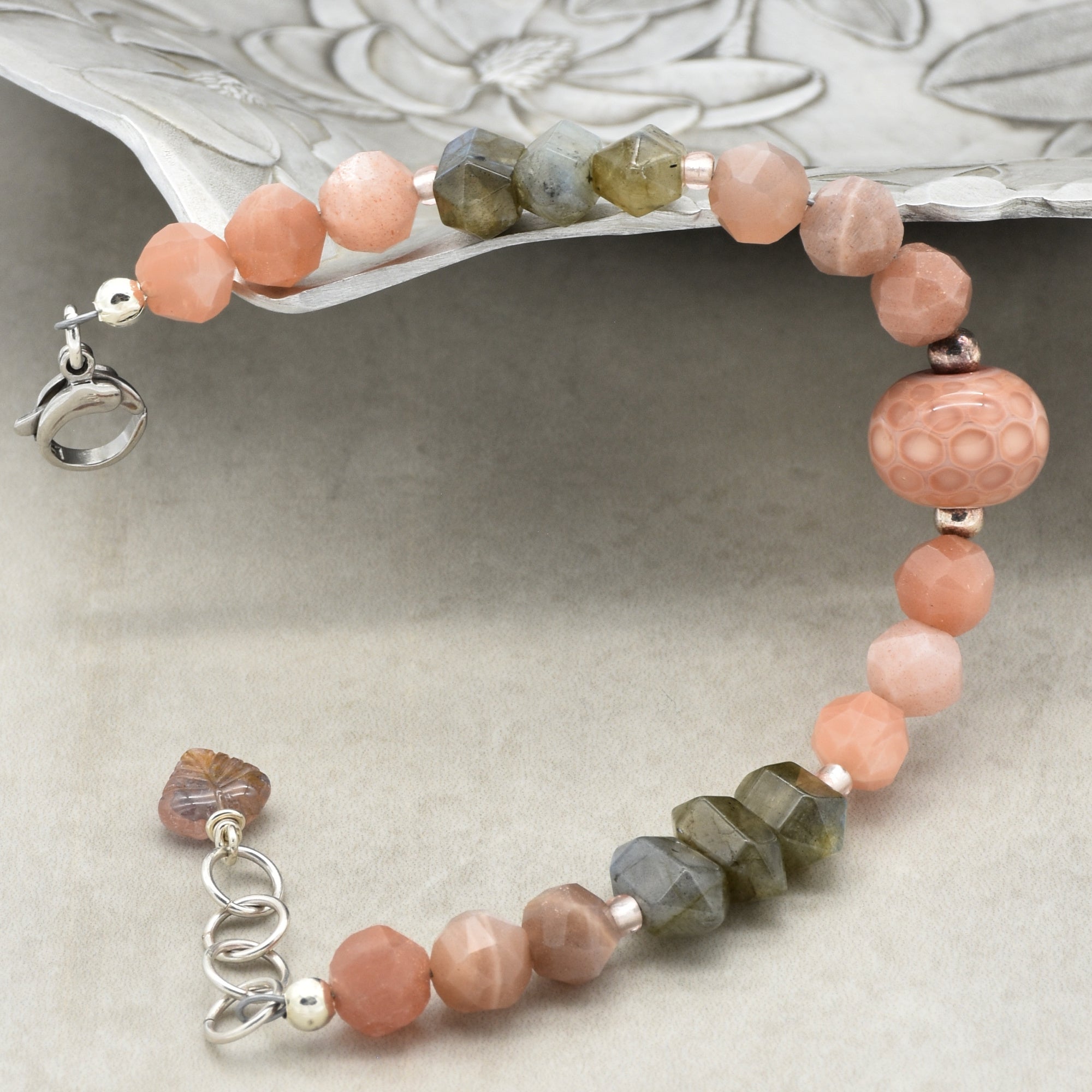 This image shows a bracelet. The size and shape of the piece, along with the clasp style and arrangement of beads, indicate that it is designed to be worn around the wrist. It is not long enough to be a necklace and does not have the structure of an earring.