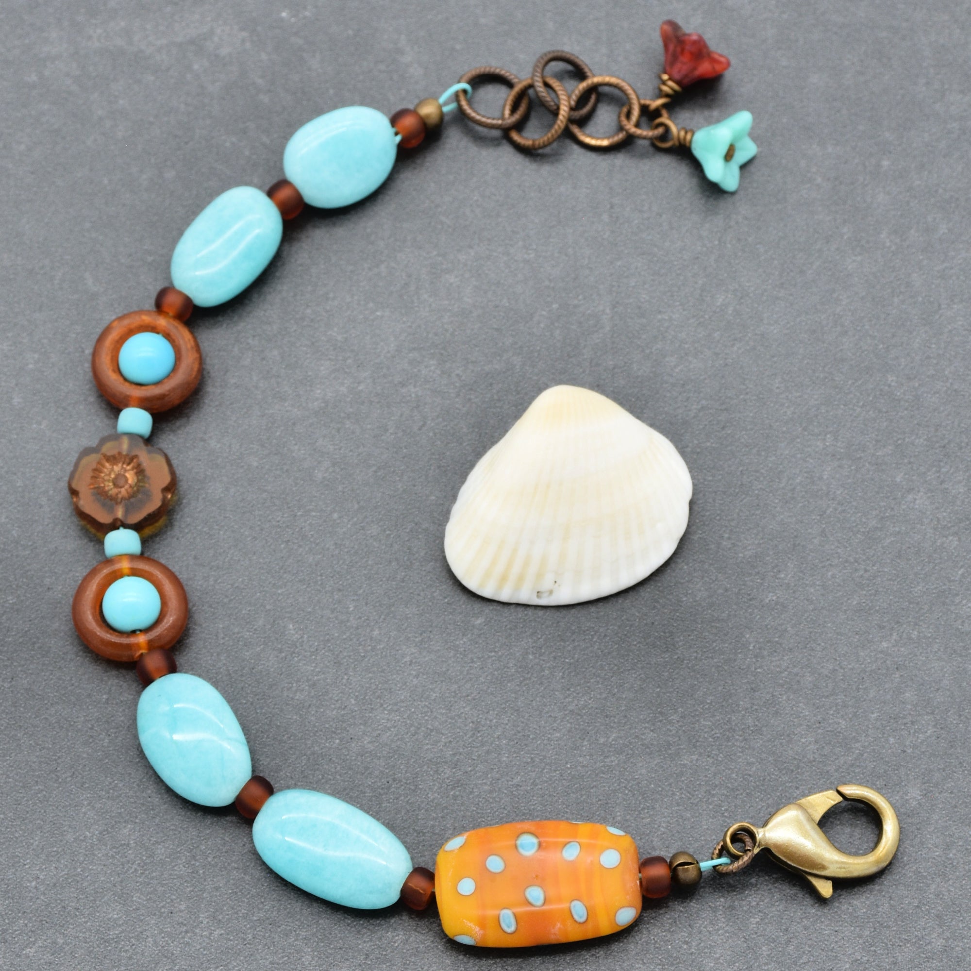 This image shows a bracelet. The size and the clasp that is visible are typical features of a bracelet rather than a necklace or earrings. The beaded design and the arrangement of decorative elements also suggest it is meant to be worn around the wrist.