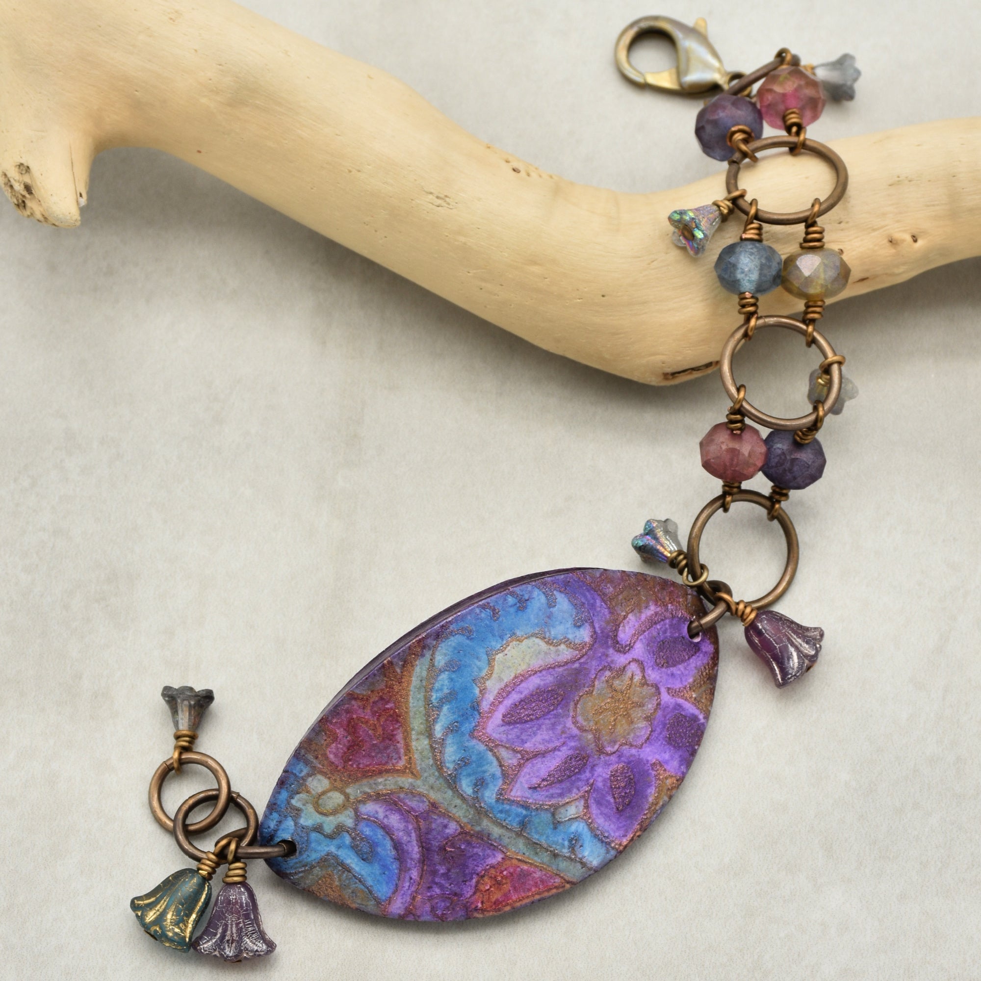 This image shows a bracelet. The jewelry piece has a clasp typical for bracelets, linking rings, and small decorative beads, along with a central decorative piece.