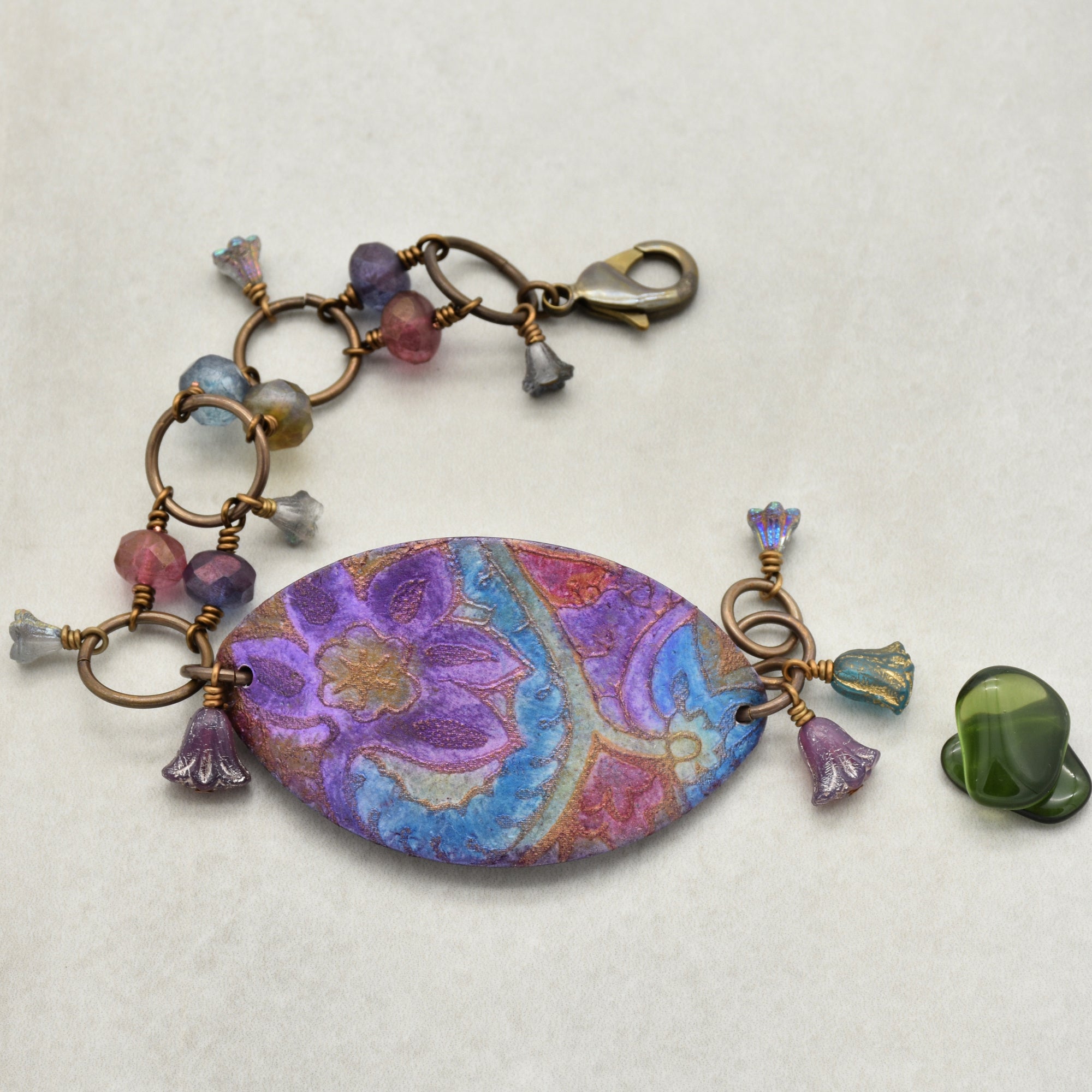 This image shows a bracelet. The size, shape, and clasp are characteristic of a bracelet rather than a necklace or earring. The decorative beads and large central piece are consistent with bracelet designs.