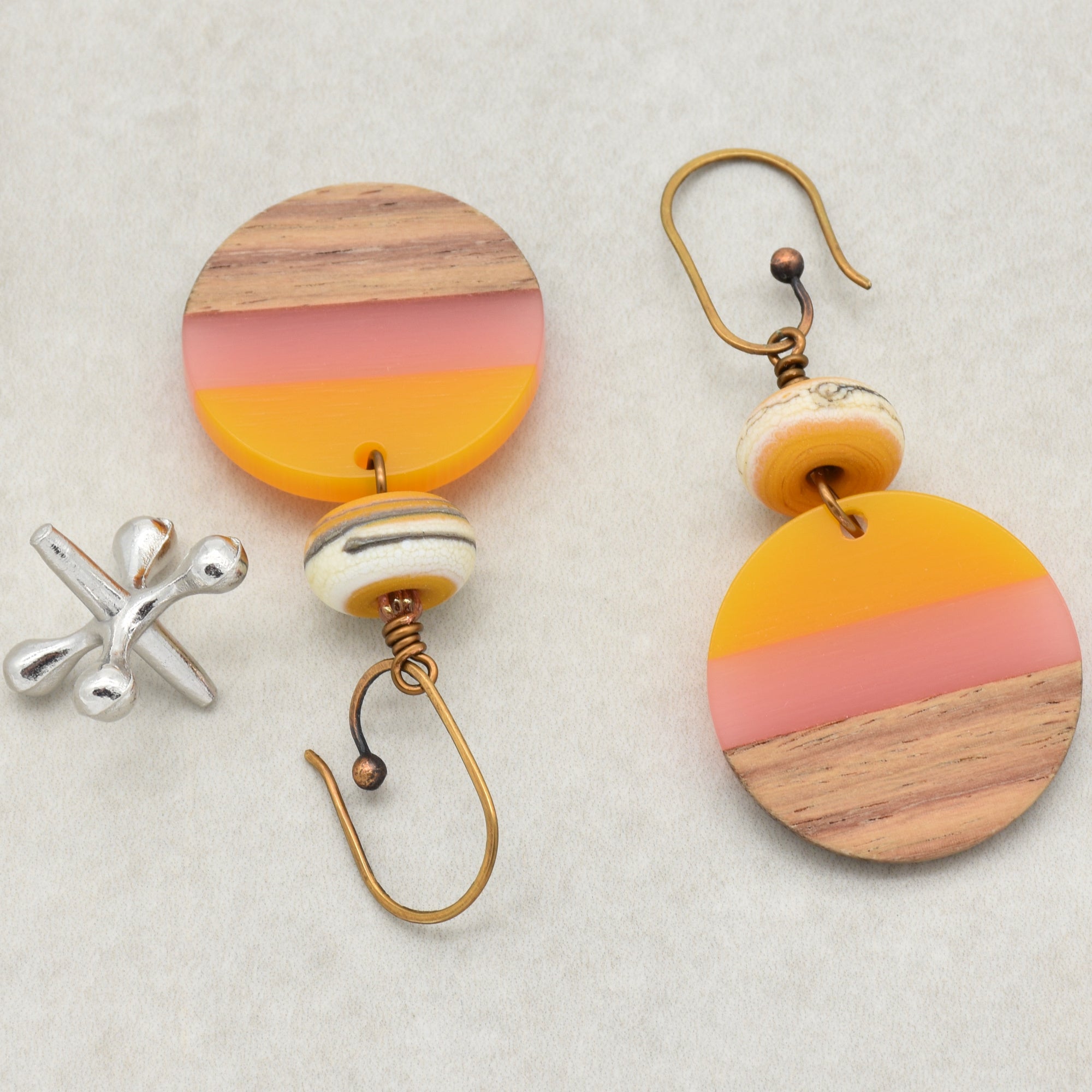 The image shows a pair of earrings. This is indicated by the hooks attached to the circular decorative pieces, which are typical of earrings.