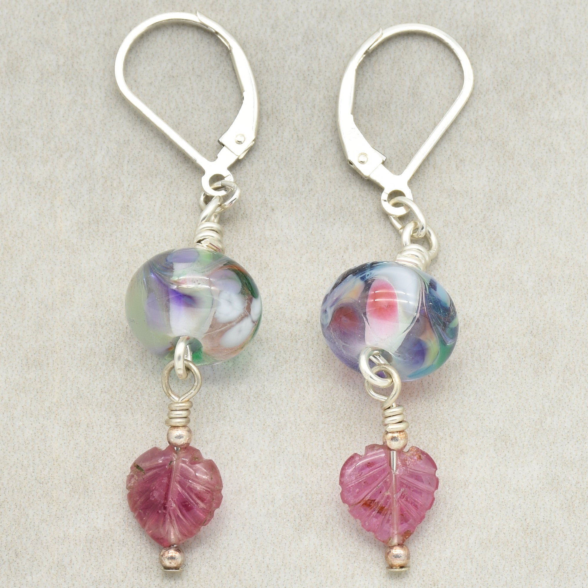 These are earrings. They have lever-back hooks, colorful round beads, and pink leaf-shaped charms hanging below the beads.