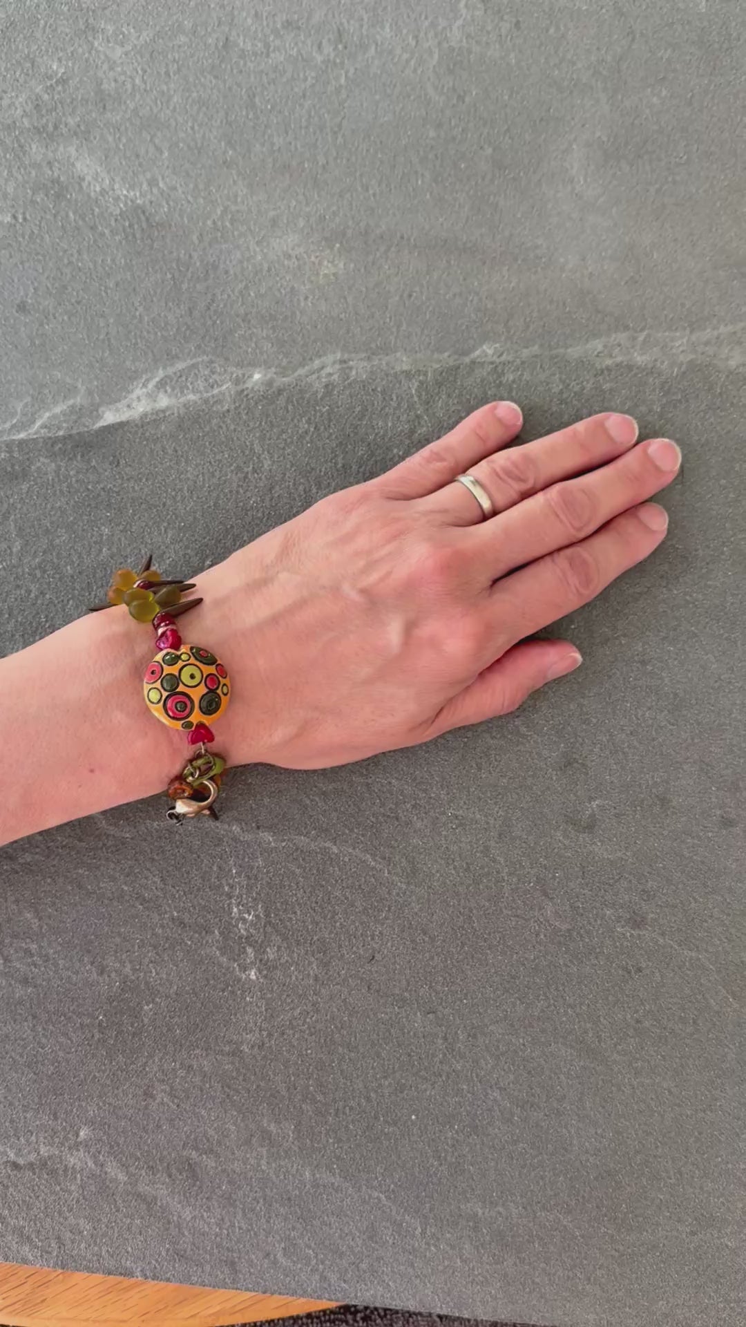 Video of Circles and Spikes bracelet with artisan ceramic focal and green, brown and orange Czech glass beads