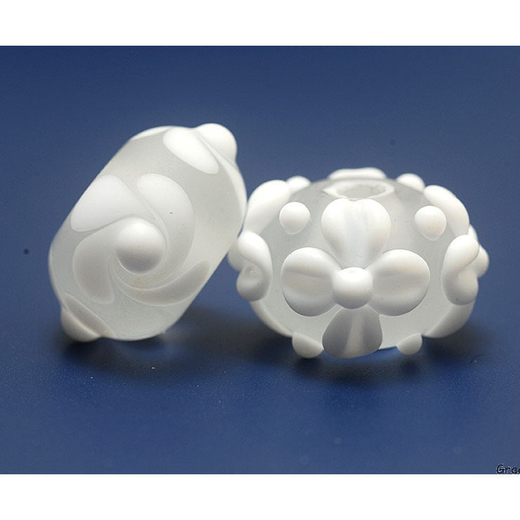 Two white lampwork beads by Grace Ma on a blue background