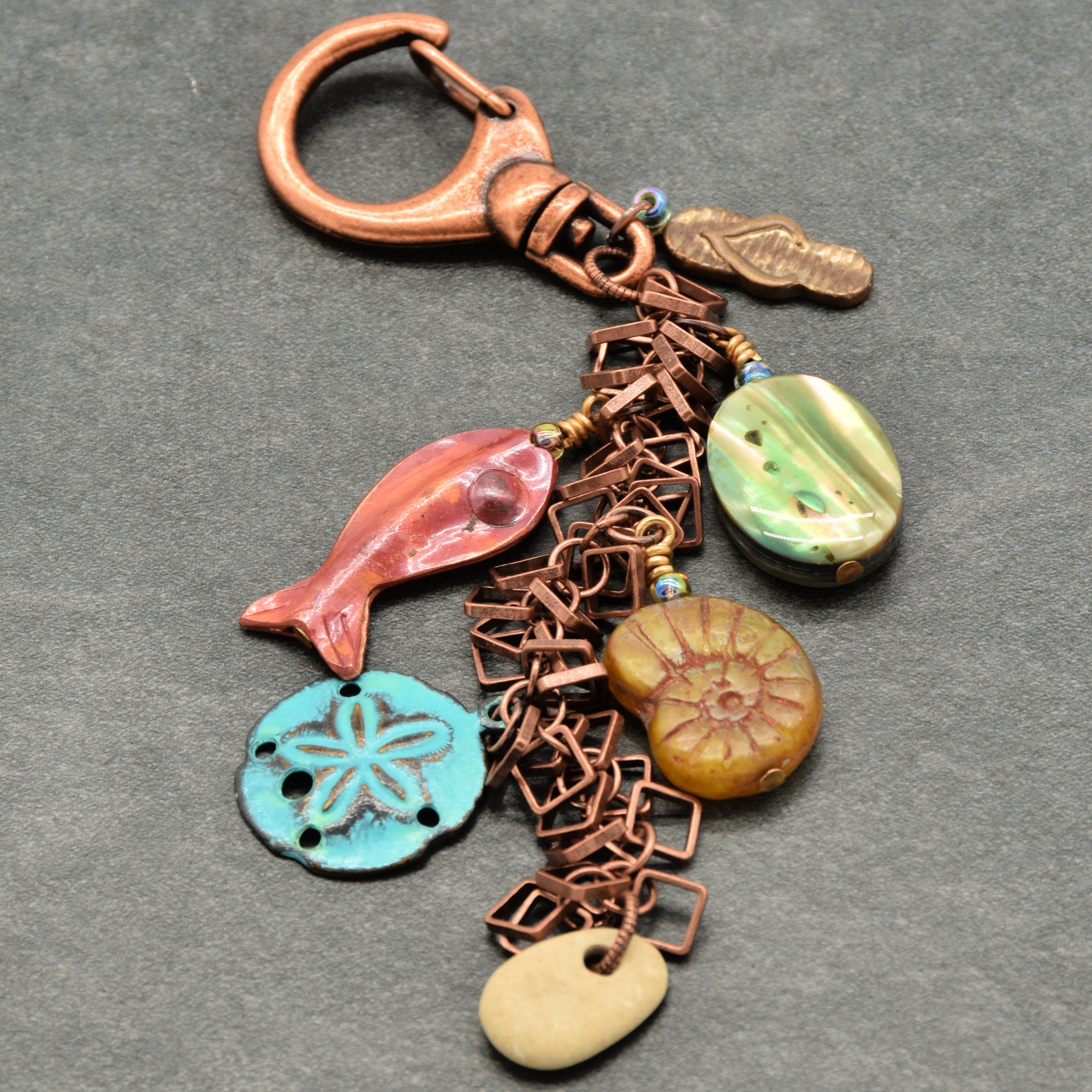 Decorative keychain with various charms on a gray background