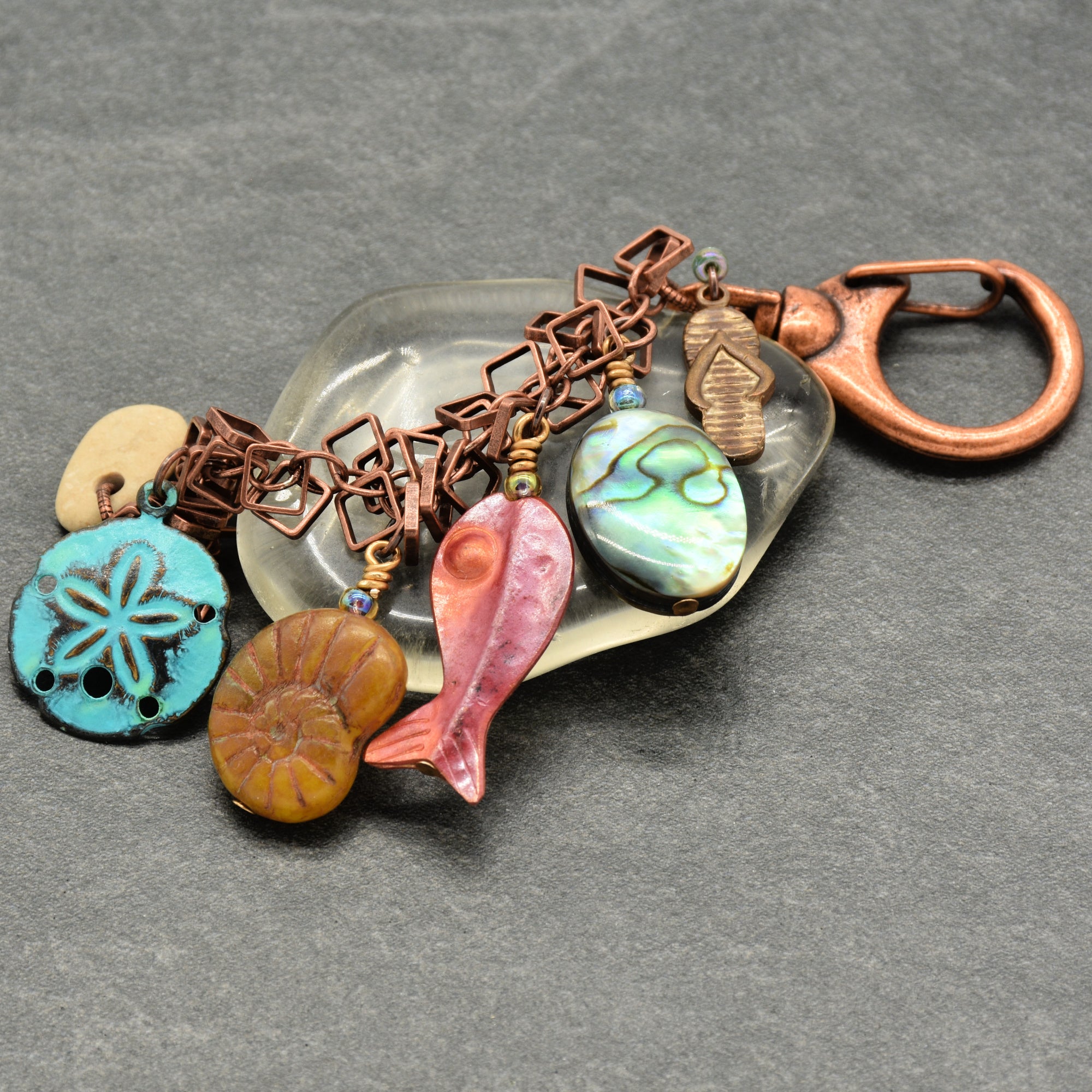 Decorative keychain with various charms on a gray background
