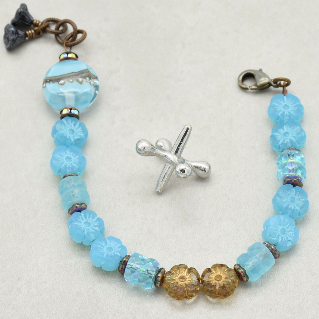 Beaded bracelet with blue and gold beads on a white background