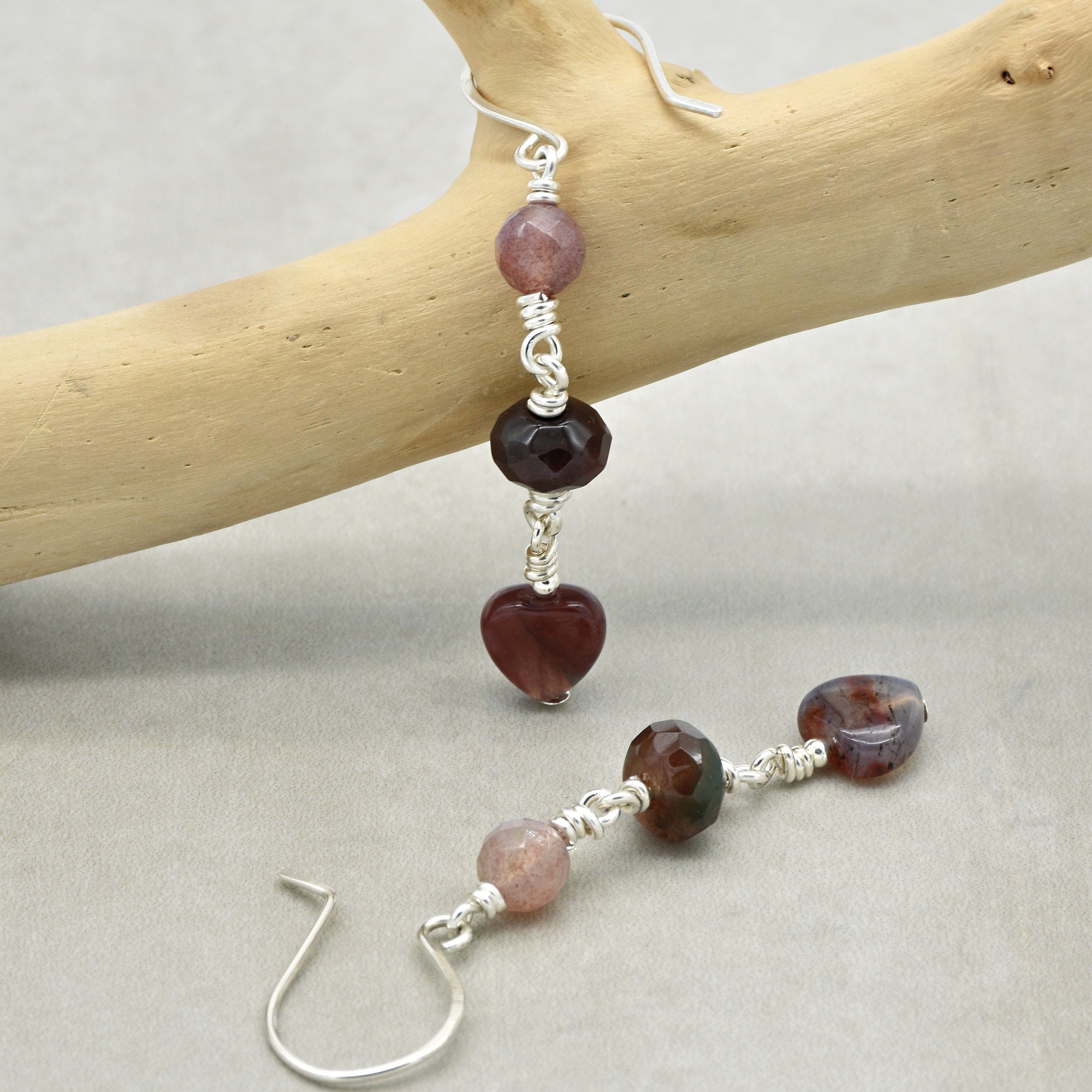 The jewelry in the image is a pair of earrings. The presence of hooks designed for piercing ears indicates that these are earrings.