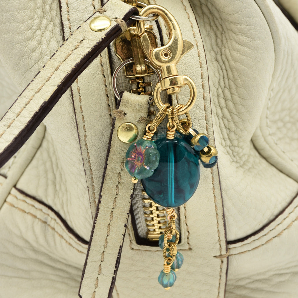 Aqua Blue handbag charm with gold swivel lobster claw on a cream purse - handmade with love by Ruby Acorn