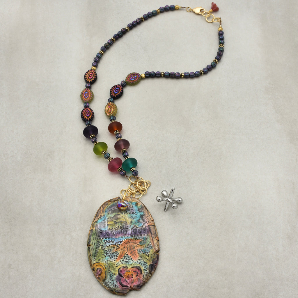 Colorful beaded necklace with a large decorative pendant on a light gray background