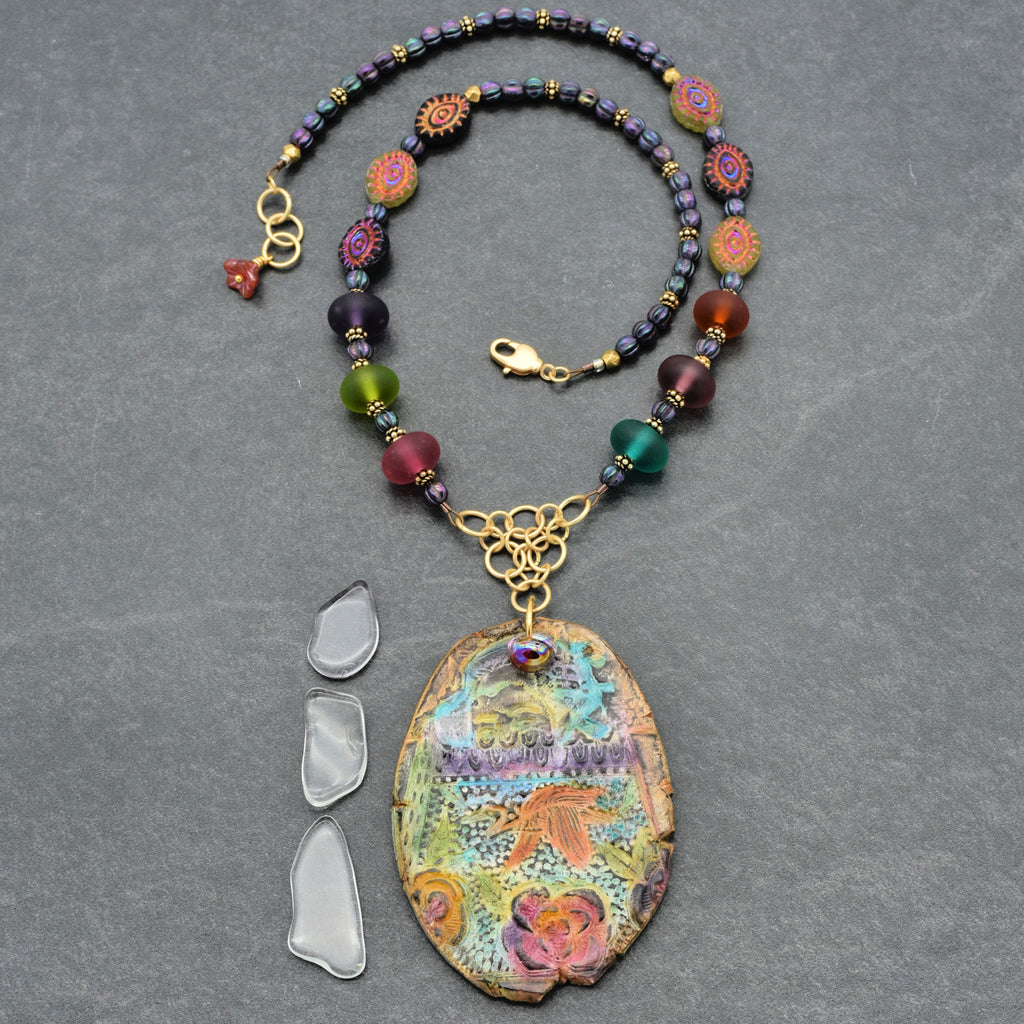 Colorful beaded necklace with a decorative pendant on a gray background
