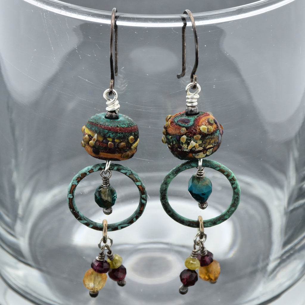 Pair of beaded earrings on a clear glass surface