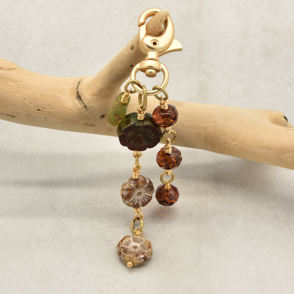 Harvest Bloom Handbag Charm featuring wire-wrapped rust hibiscus flowers and olive green maple leaf charm, handmade by Ruby Acorn