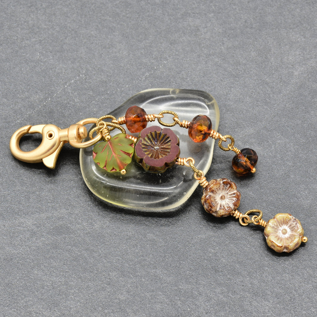 Harvest Bloom Handbag Charm featuring wire-wrapped rust hibiscus flowers and olive green maple leaf charm, handmade by Ruby Acorn