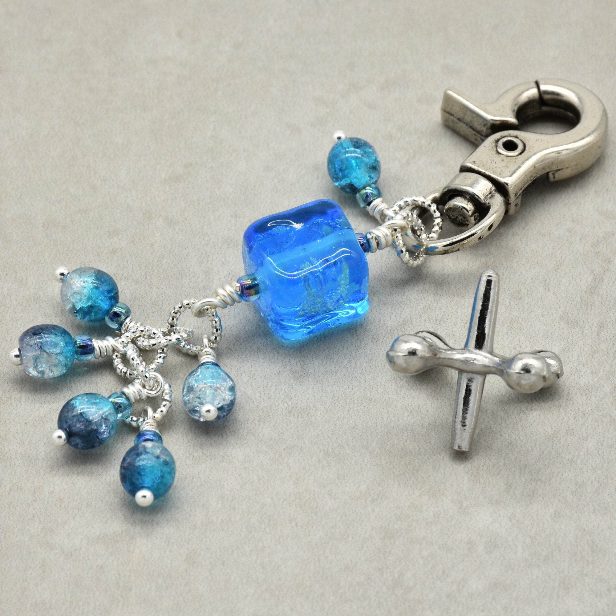 Keychain with blue beads and silver clasp on a gray background