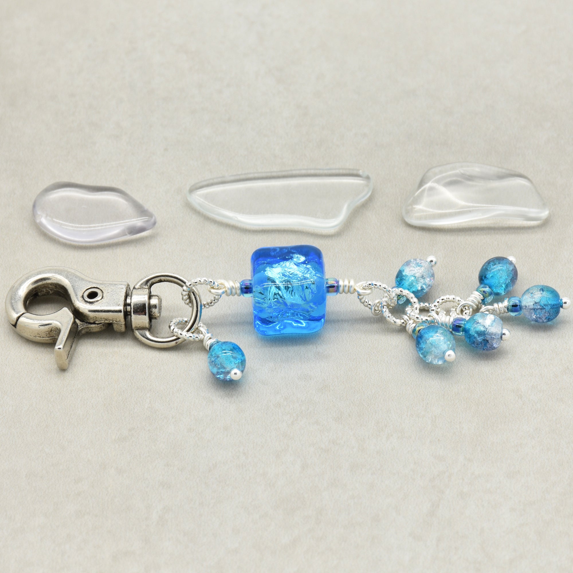 Blue beaded keychain with silver clasp on a light gray background