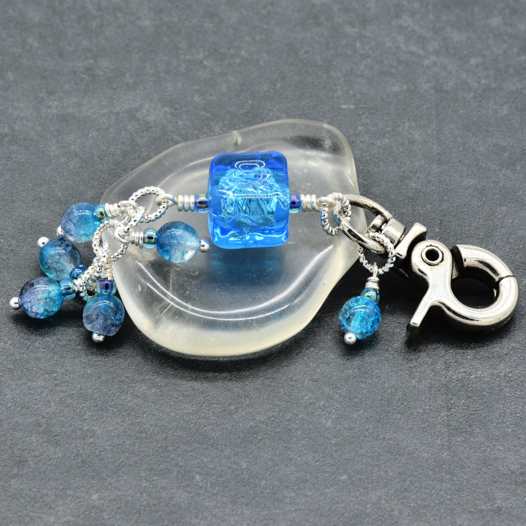 Blue beaded keychain with a silver clasp on a gray background