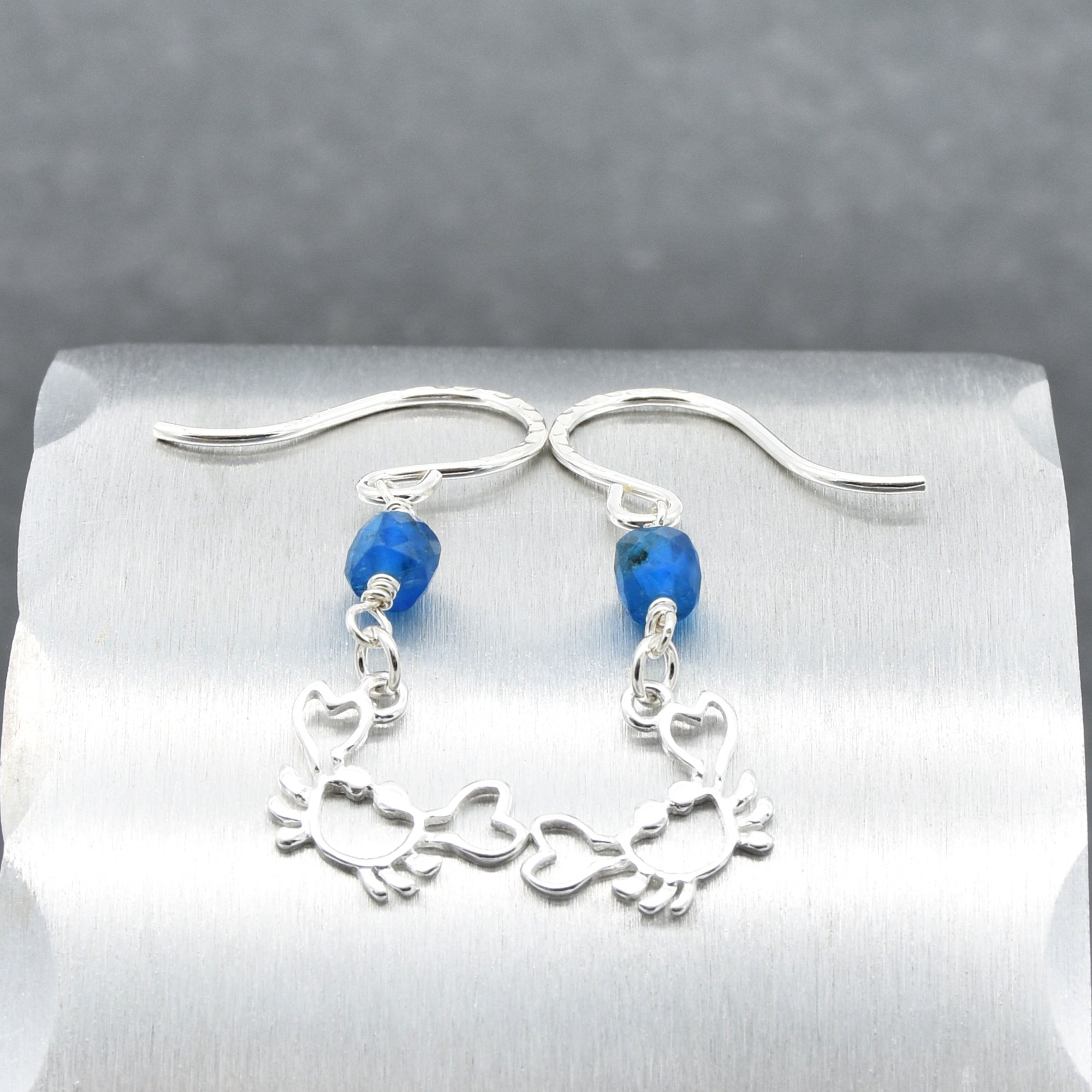 Sterling silver dangle earrings with crab charms, apatite, and silver ear wires on a silver surface - handmade with love by Ruby Acorn