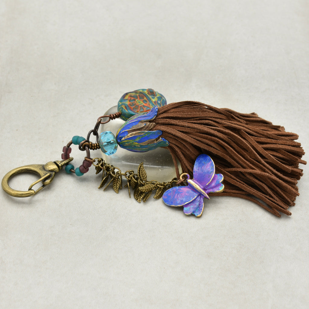 Keychain with butterfly charm and tassel on a light background