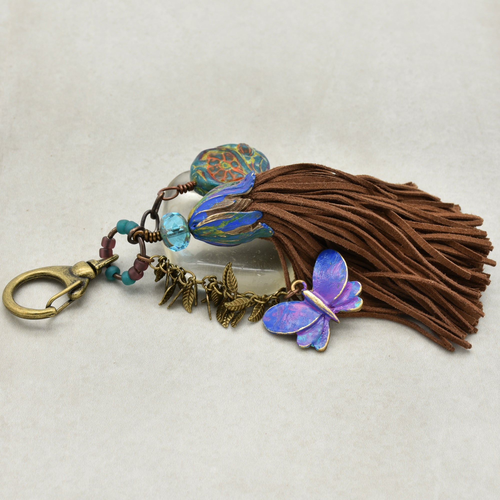 Keychain with butterfly charm and tassel on a light background
