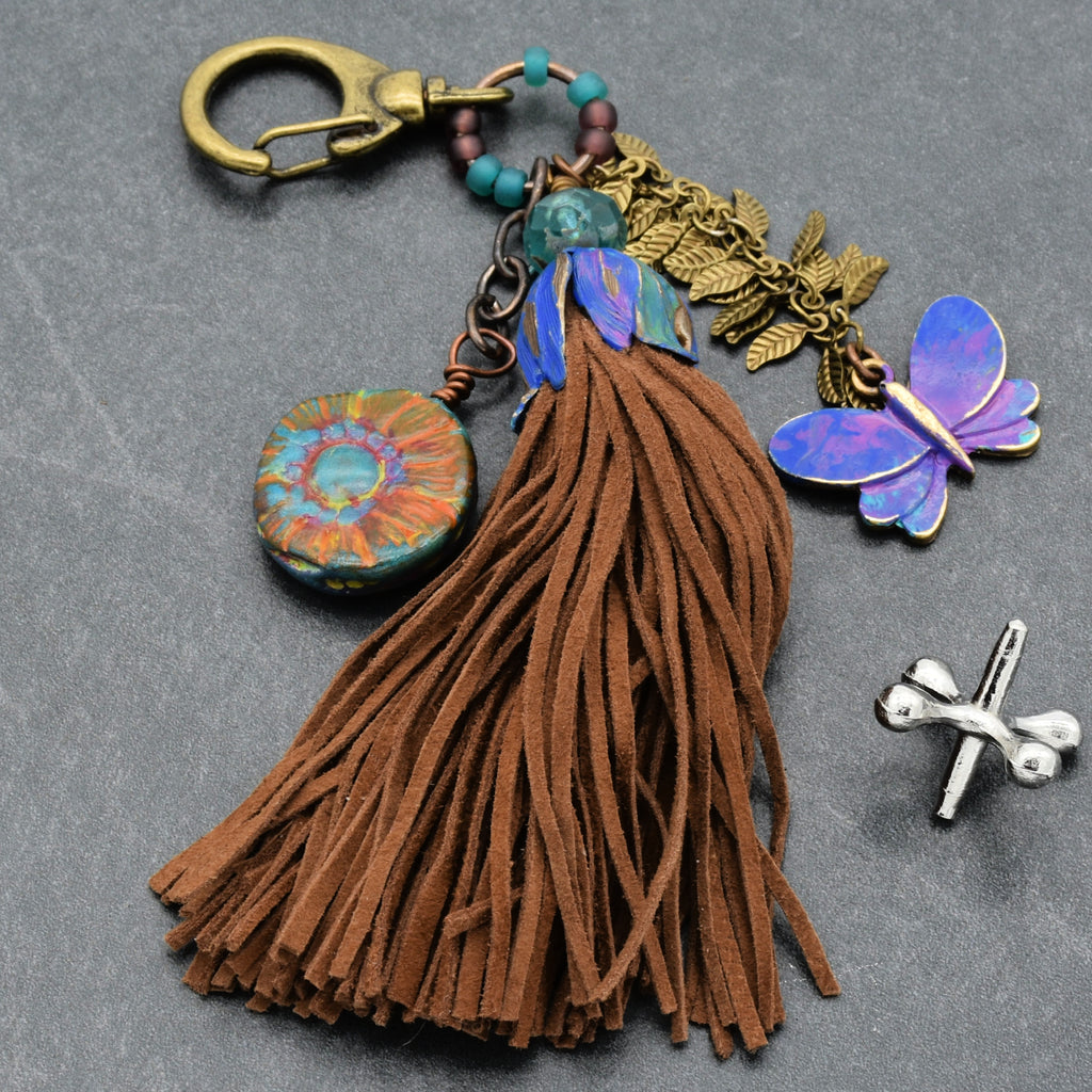 Keychain with tassel, butterfly charm, and decorative elements on a gray background