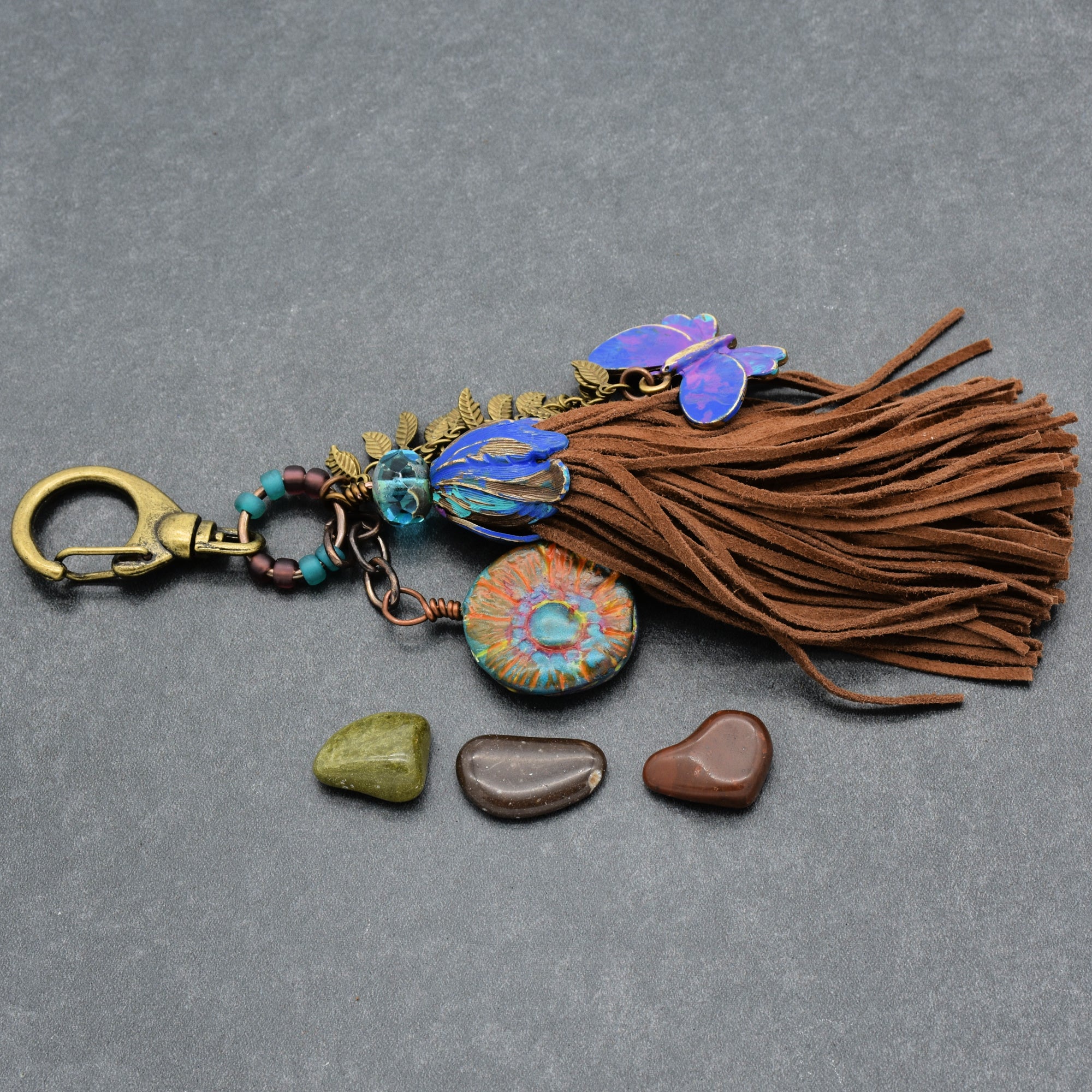Keychain with tassel, stones, and decorative elements on a gray background