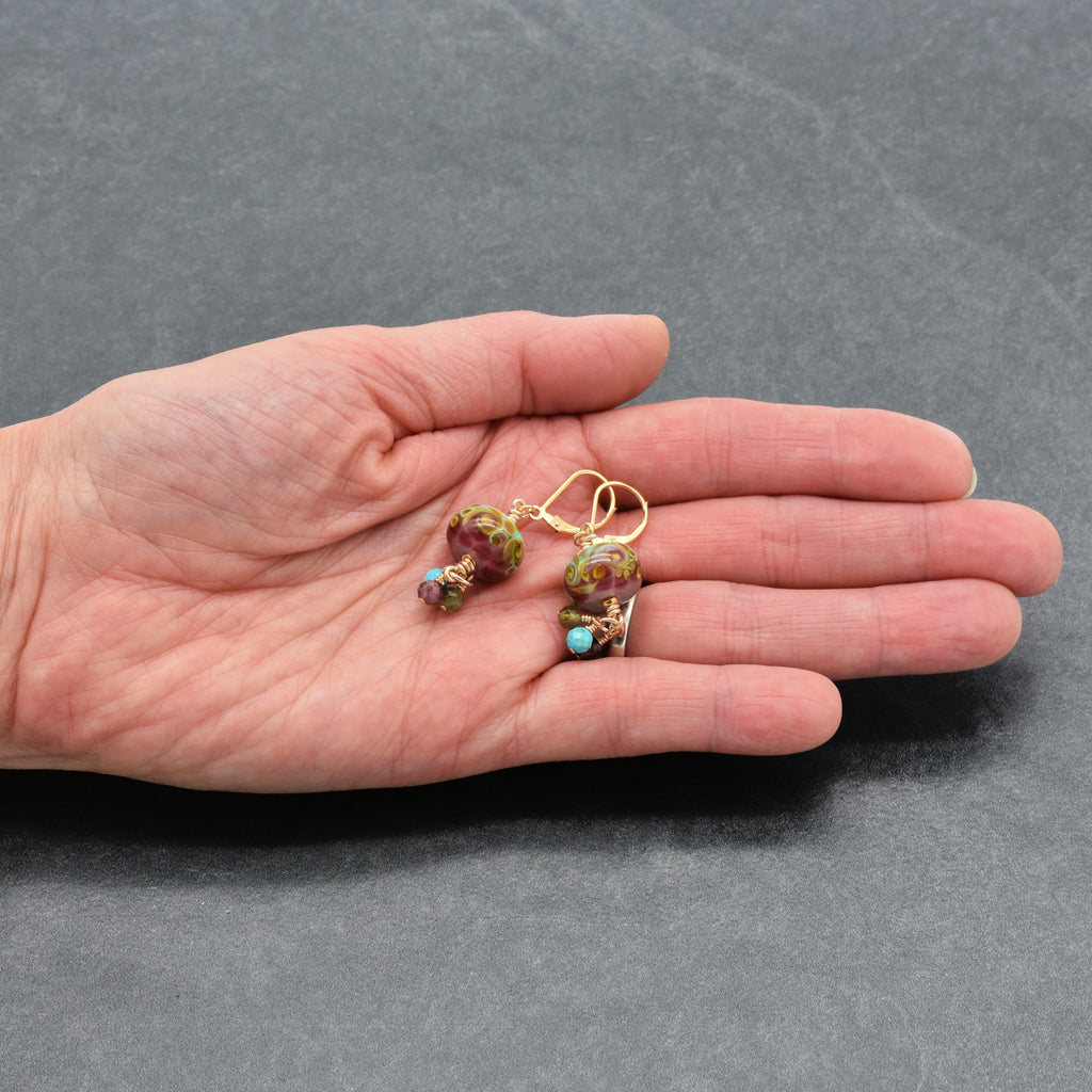 Hand holding colorful earrings with gold filled lever back ear wires 