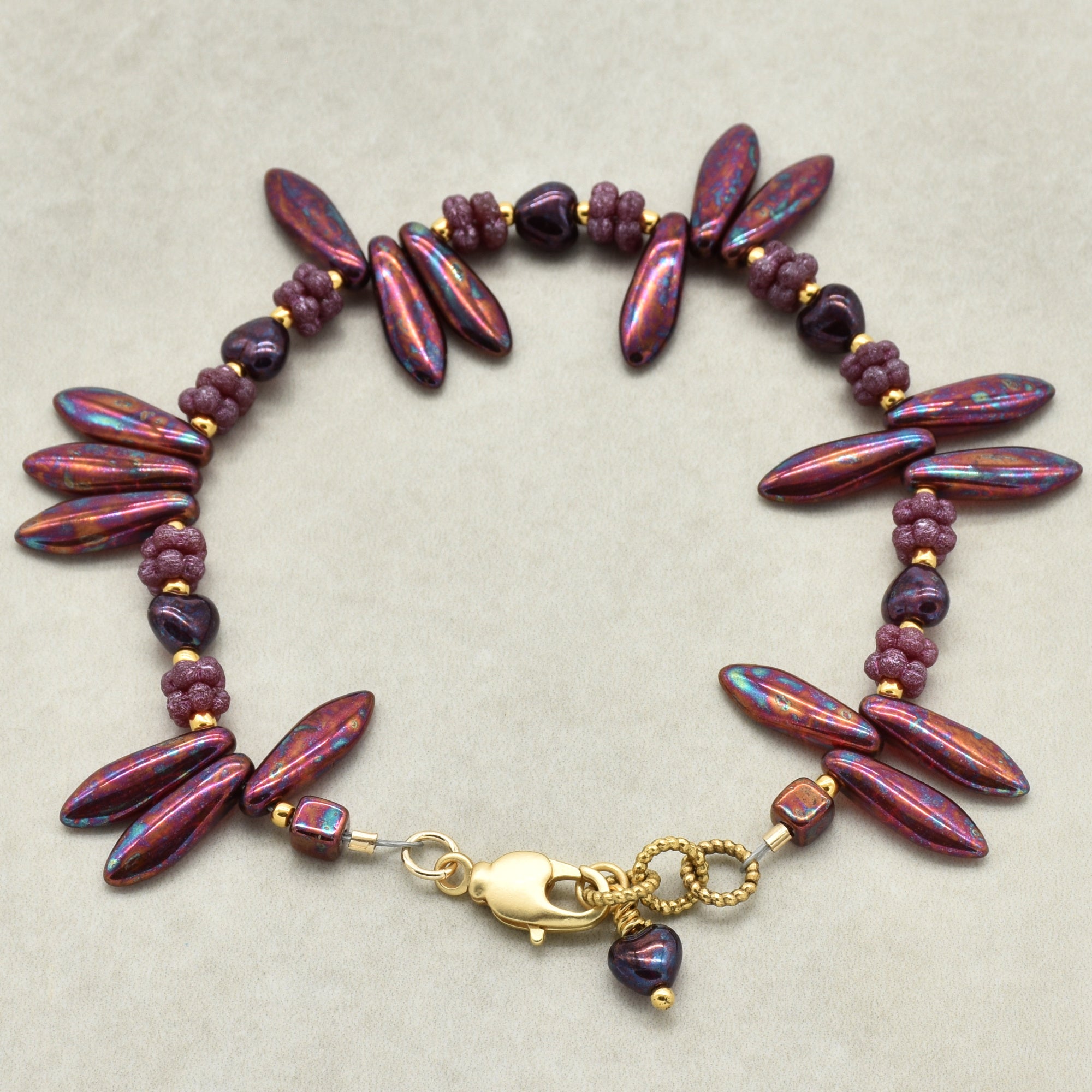 Beaded bracelet with gold clasp on a beige background