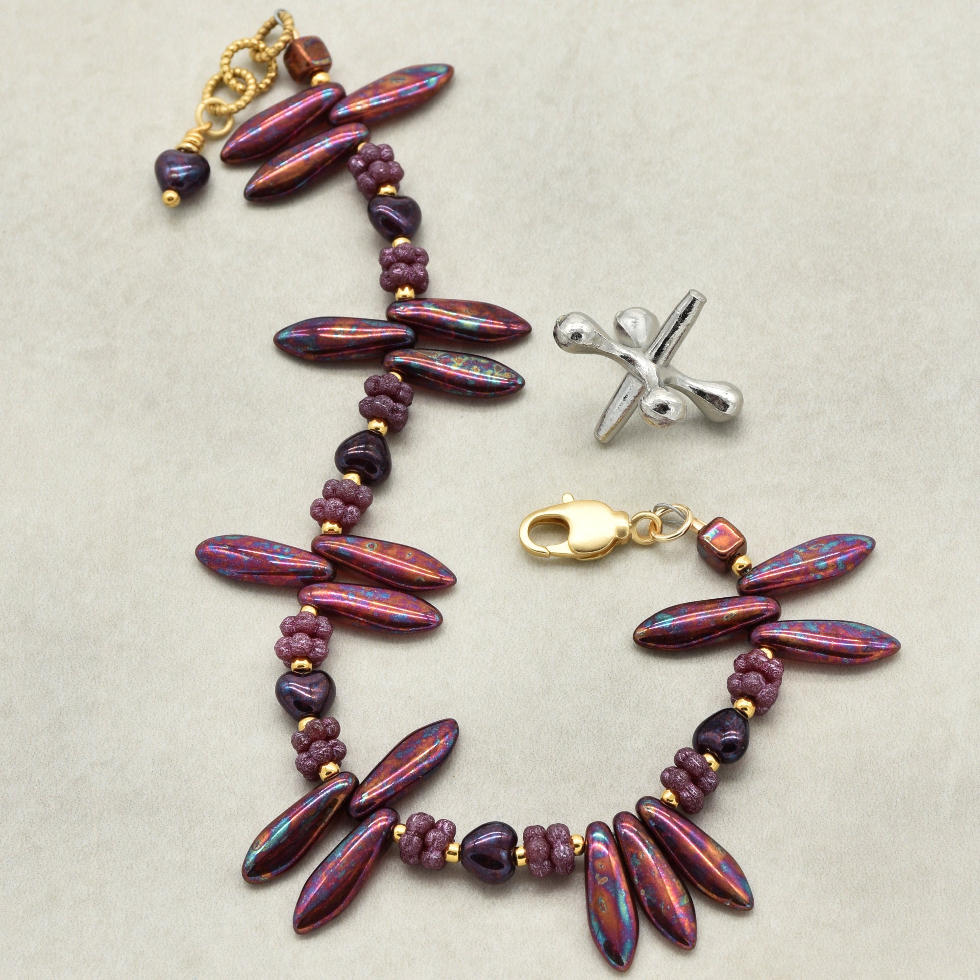 Beaded bracelet with a gold clasp on a beige background