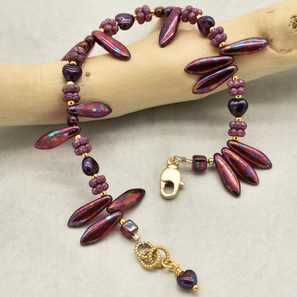 Beaded bracelet with gold clasp on a wooden branch