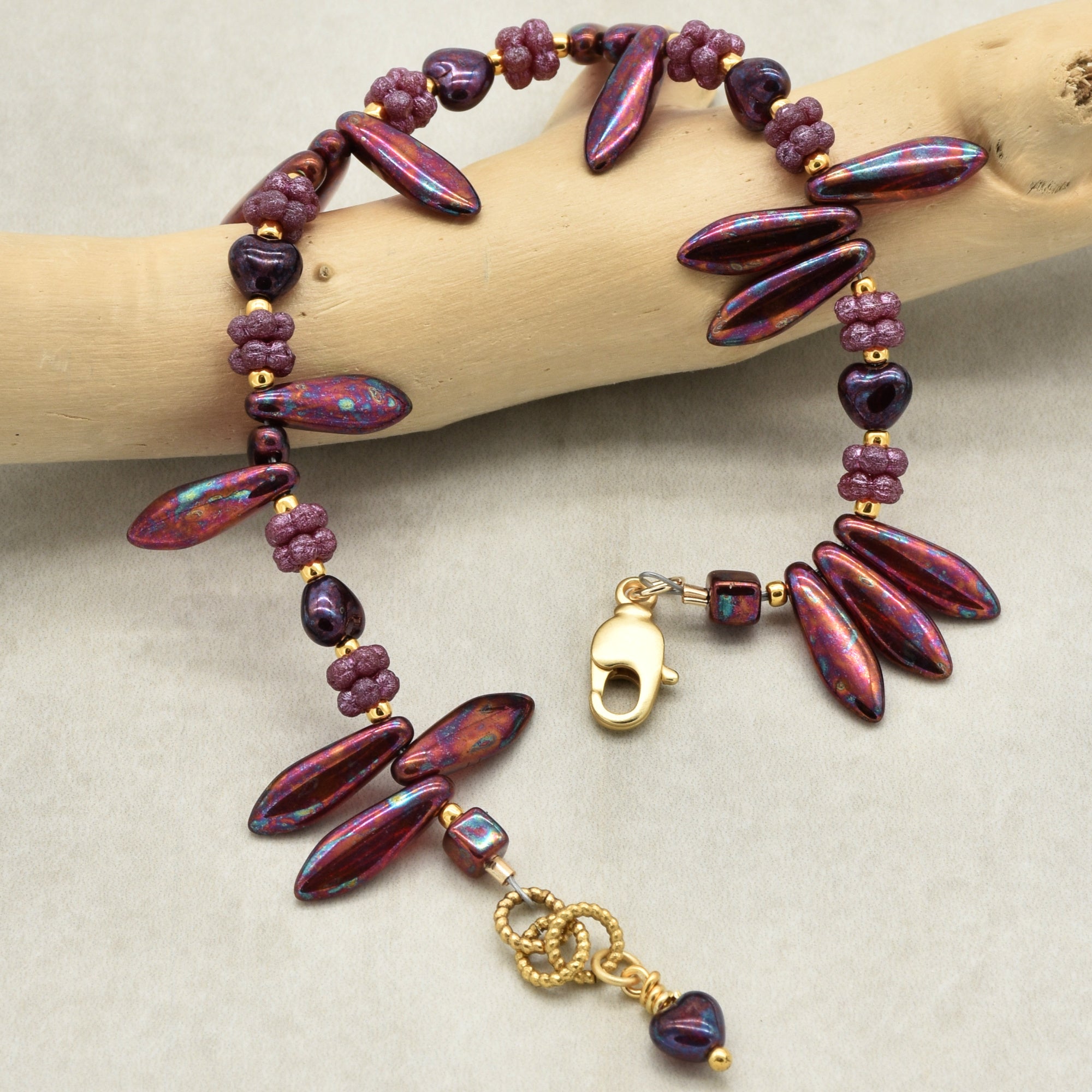 Beaded bracelet with gold clasp on a wooden branch