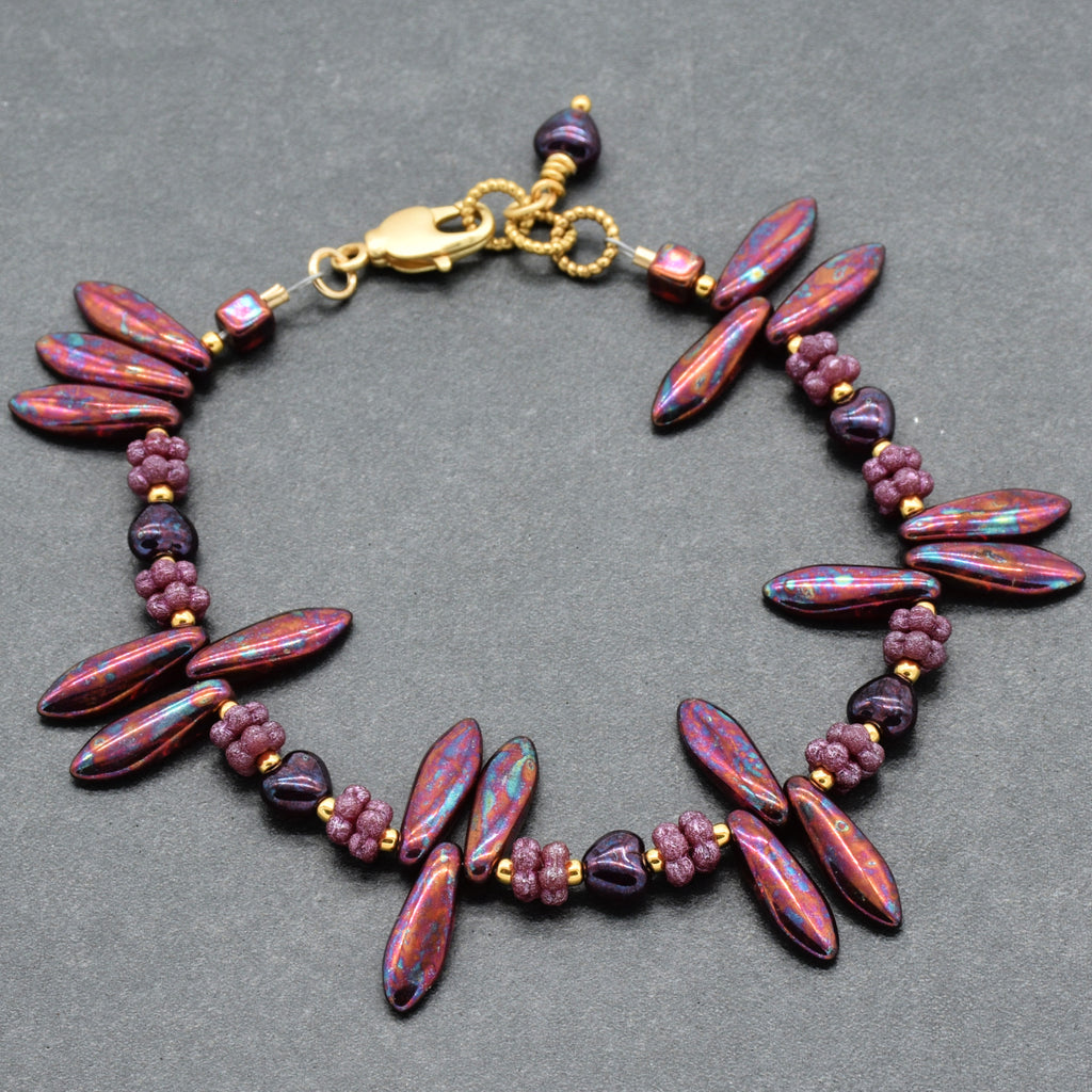 Beaded bracelet with burgundy beads on a gray background